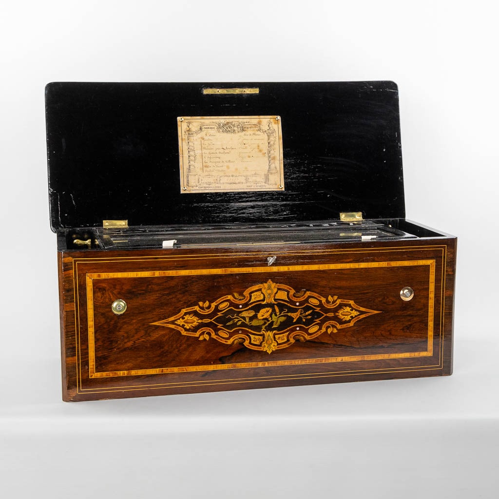 A large music box with an internal organ, in a marquetry inlay box. (L:30 x W:71 x H:27 cm): A large music box with an internal organ, in a marquetry inlay chest. The chest is nicely finished with a floral motif. The music system has an added organ. In working condition at the moment. All tee