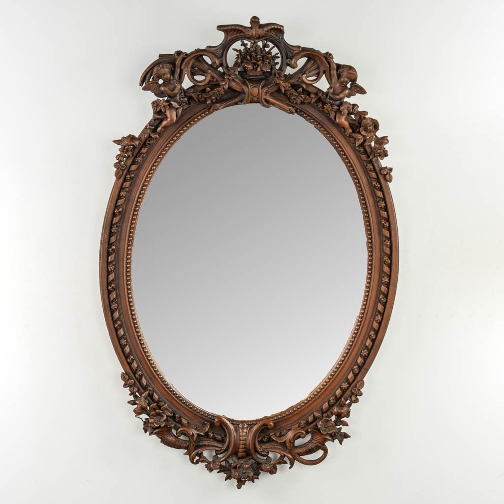 An oval mirror, patinated stucco decorated with angels and flowers in a Louis XVI style. Circa 1920.: An oval mirror, patinated stucco decorated with angels and flowers in a Louis XVI style. Circa 1920. Dutch Description: Een ovale spiegel, gepatineerde stucco met engelen en bloemendecor, Lodewijk XVI