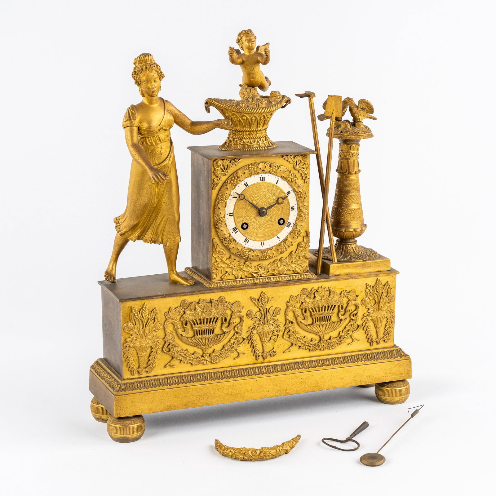 A mantle clock, 'Lady with a garland, Lovebirds and an Angel', gilt bronze. Empire.: A mantle clock, 'Lady with a garland, Lovebirds and an Angel', gilt bronze. Empire., Lady with garland (loose but present).¬†, Angel on top of a flower basket, and a pair of lovebirds.¬†, Silk r