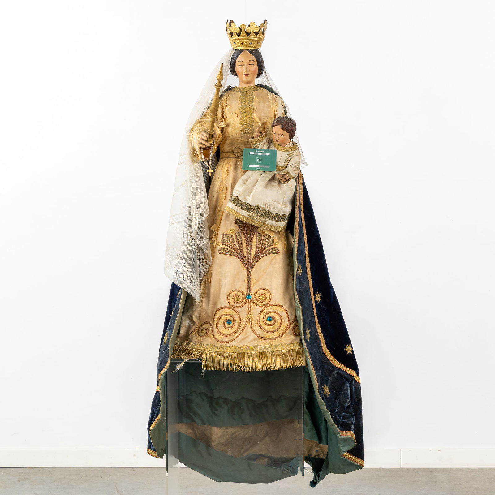 An antique wood-sculptured Madonna with a Child', finished with embroideries and brocade.: An antique wood-sculptured Madonna with a Child', finished with embroideries and brocade. A wood sculptured Virgin with a Child, dressed in robes decorated with Cabochons, silk and embroideries. Both