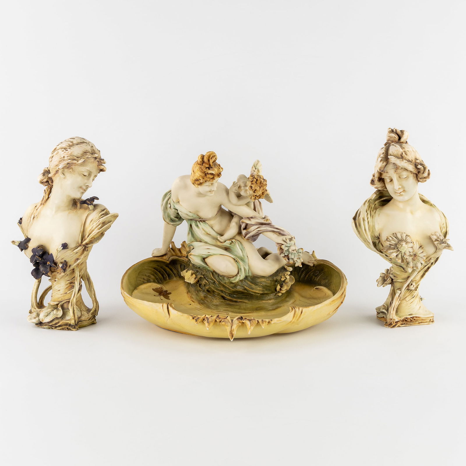 RStK Amphora, Art Nouveau, two busts and a figurative bowl, polychrome porcelain, Turn-Teplitz,: RStK Amphora, Art Nouveau, two busts and a figurative bowl, polychrome porcelain, Turn-Teplitz, Austria, circa 1900. Polychrome porcelain.A figurative bowl with a lady and a cherub (H: 27 cm).Two bu