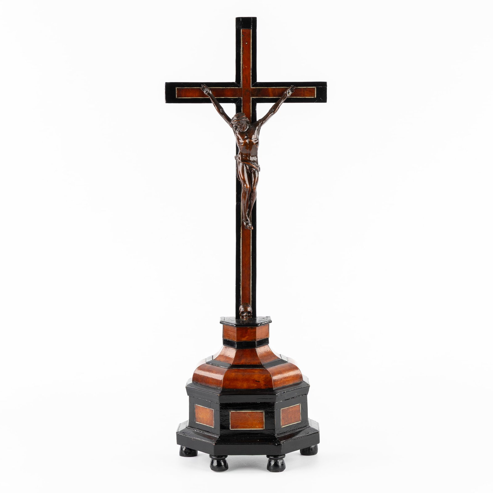 An Altar Crucifix with a Wood-Sculptured Corpus Christi and Skull of Adam, Baroque Revival.: An Altar Crucifix with a Wood-Sculptured Corpus Christi and Skull of Adam, Baroque Revival. Sculptured and ebonized wood, with veneer inlay. Mounted with a carved wood Corpus Christi and the Skull of 