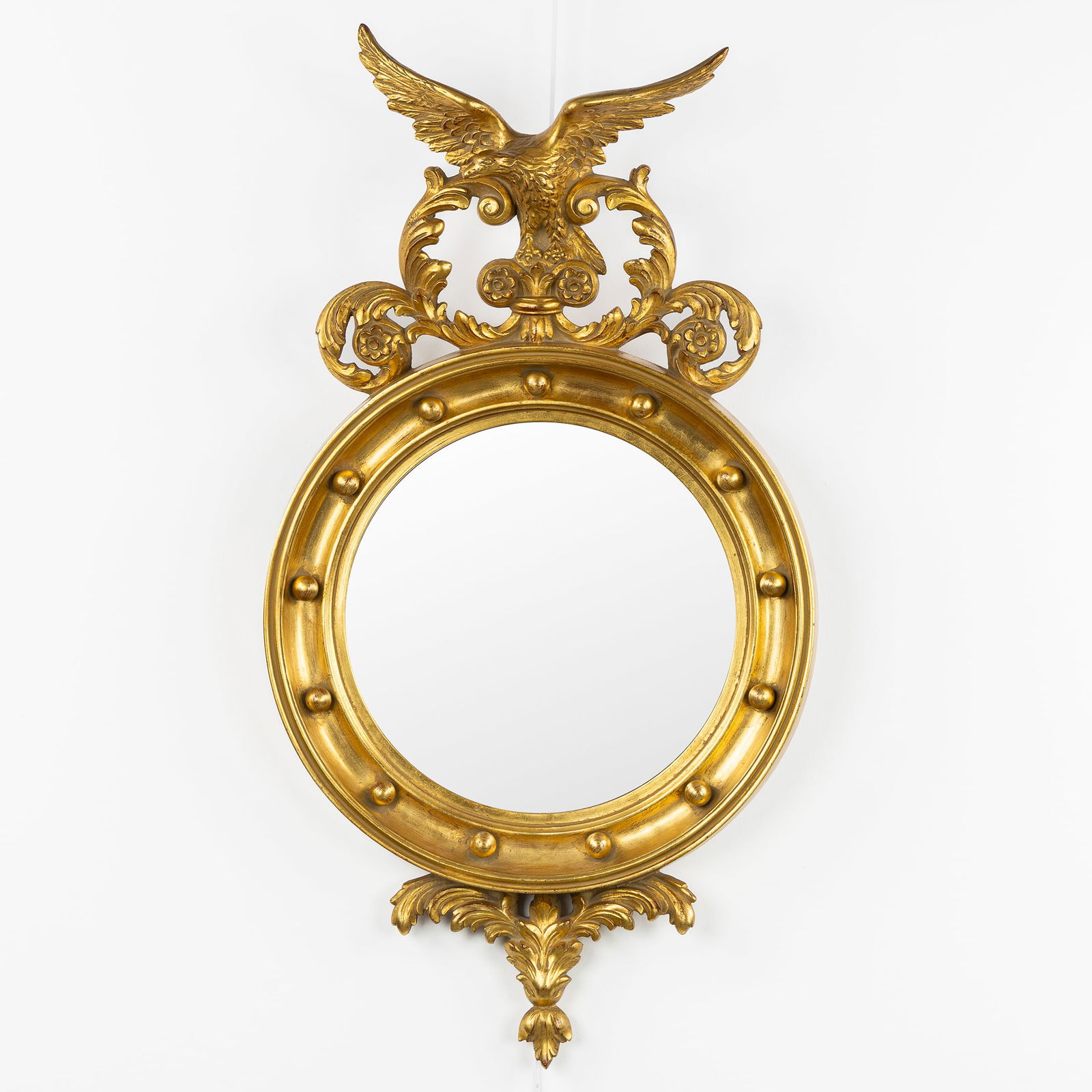 A Hollywood Regency Mirror, Decorated with an Eagle and a Convex Mirror.: A Hollywood Regency Mirror, Decorated with an Eagle and a Convex Mirror. Gilded resin and convex glass.Decorated with an eagle and acanthus leaves.Hollywood Regency style.