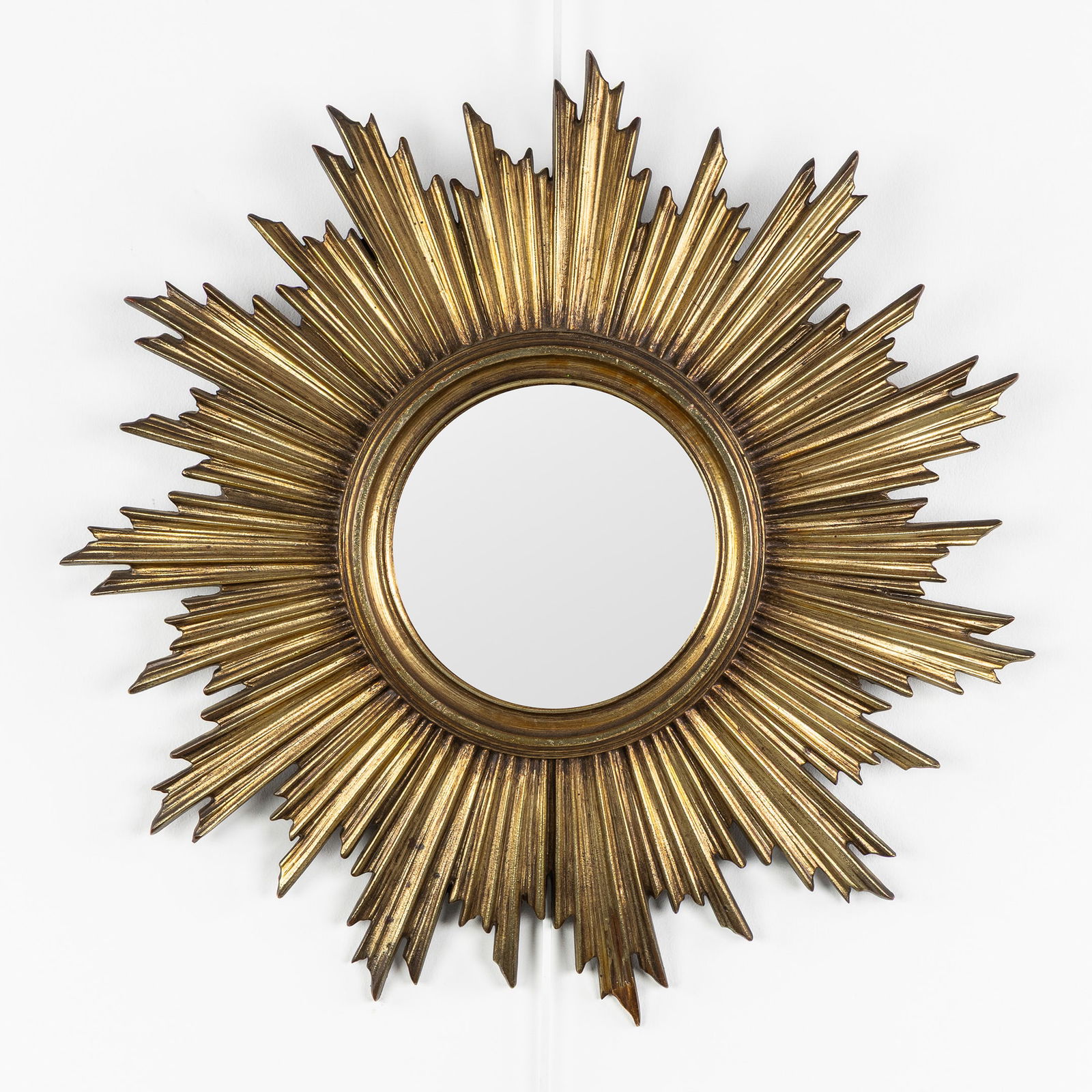 A Mid-Century Sunburst Mirror, Gilded, Convex Glass. Circa 1970.: A Mid-Century Sunburst Mirror, Gilded, Convex Glass. Circa 1970. Convex glass.Gilded resin.Probably Deknudt.Circa 1970.