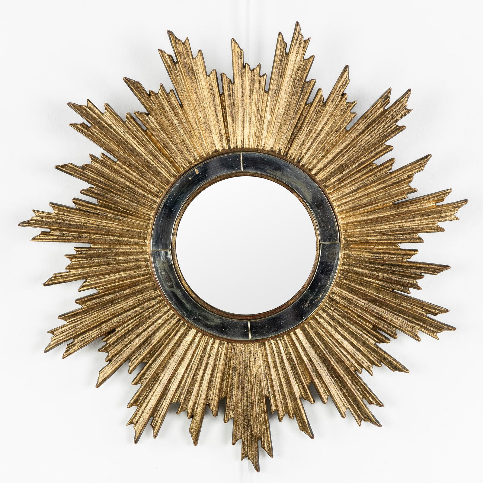A Mid-Century Sunburst Mirror, Gilded, Convex Glass. Circa 1970.: A Mid-Century Sunburst Mirror, Gilded, Convex Glass. Circa 1970. Convex glass.Gilded resin.Probably Deknudt.Circa 1970.