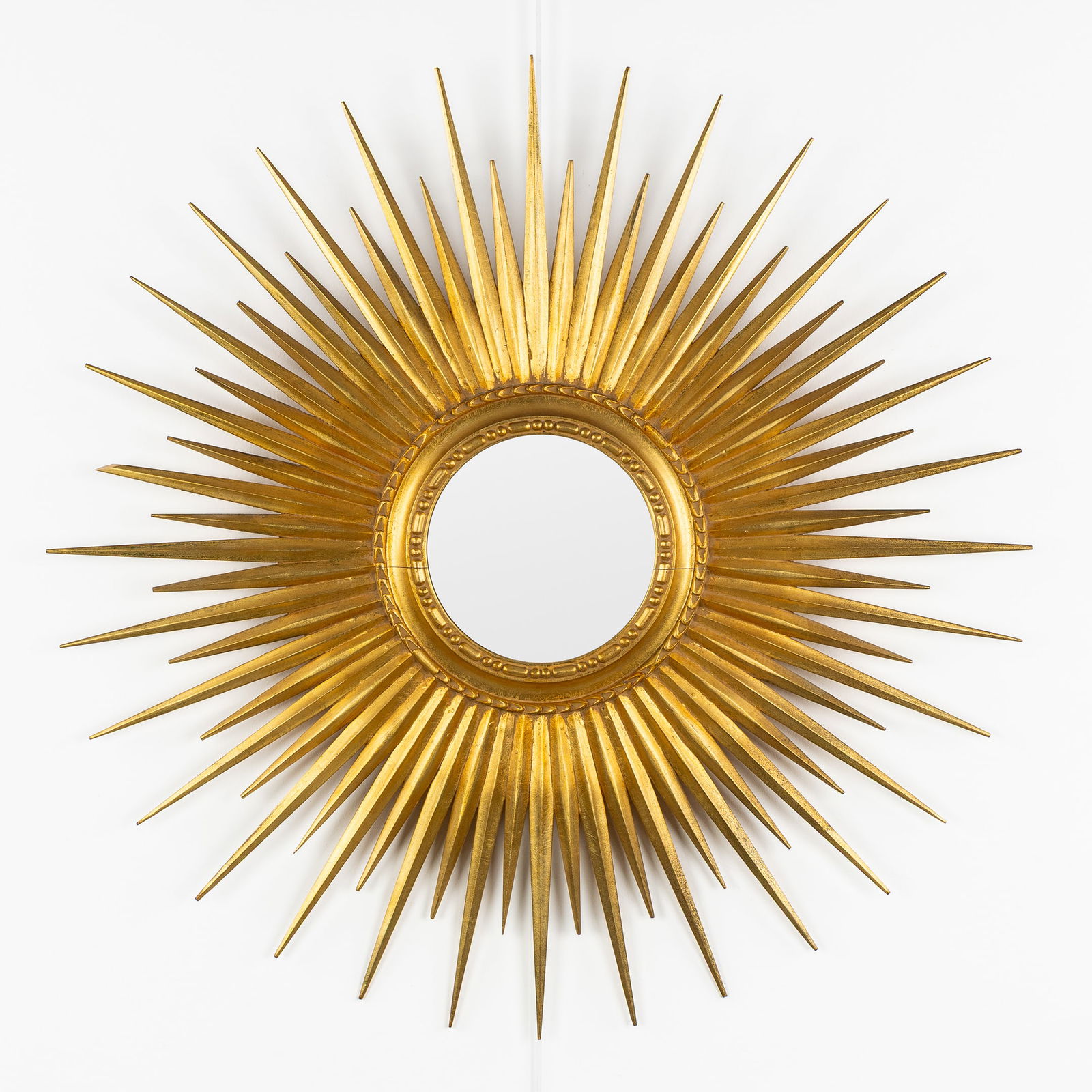 A Large Mid-Century Sunburst Mirror, Gilded, Wood-Sculptured, Convex Glass. Circa 1970.: A Large Mid-Century Sunburst Mirror, Gilded, Wood-Sculptured, Convex Glass. Circa 1970. Convex glass.Gilded wood.Circa 1970.