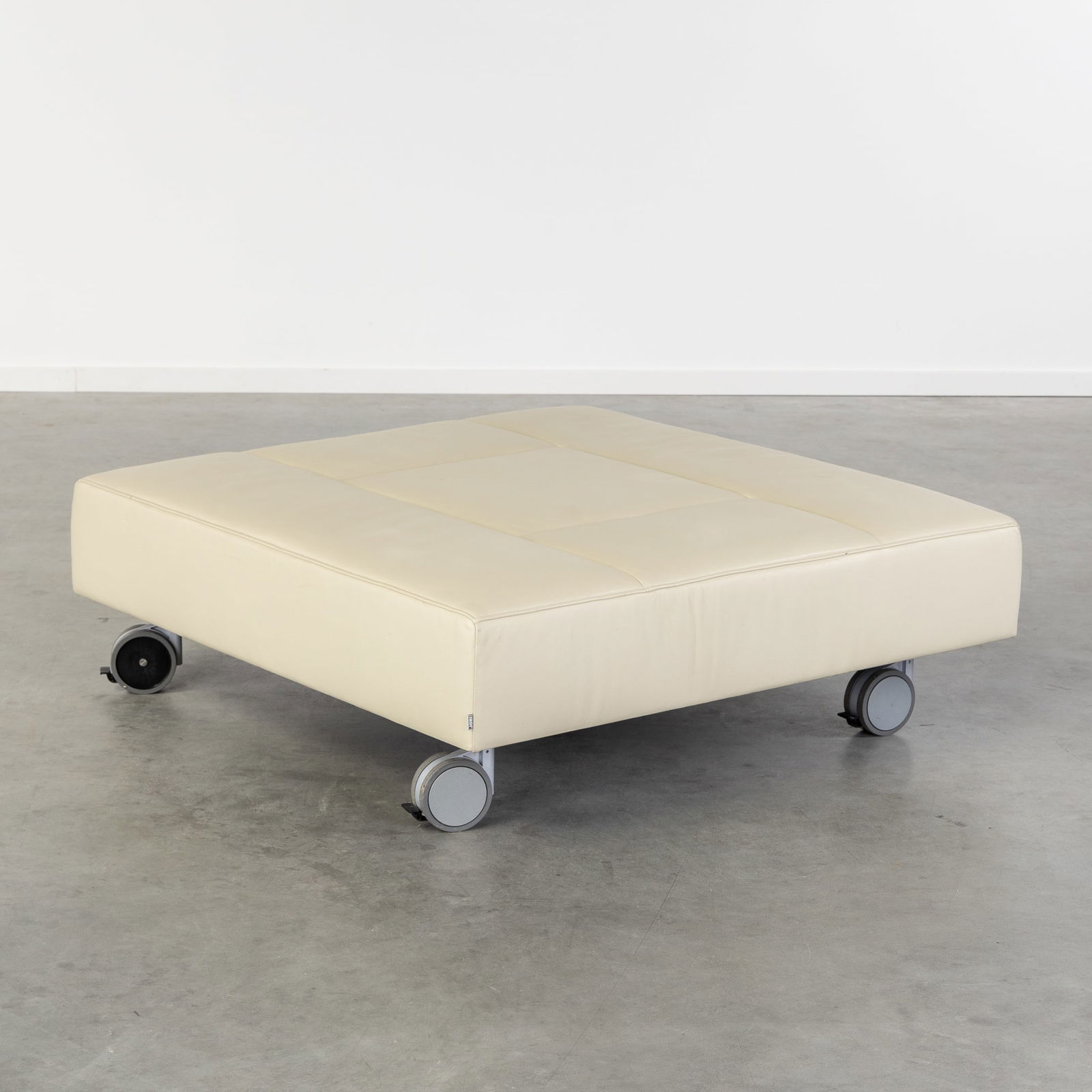 Jori, a large leather ottoman on wheels.: Jori, a large leather ottoman on wheels. Creme leather.Mounted on wheels.