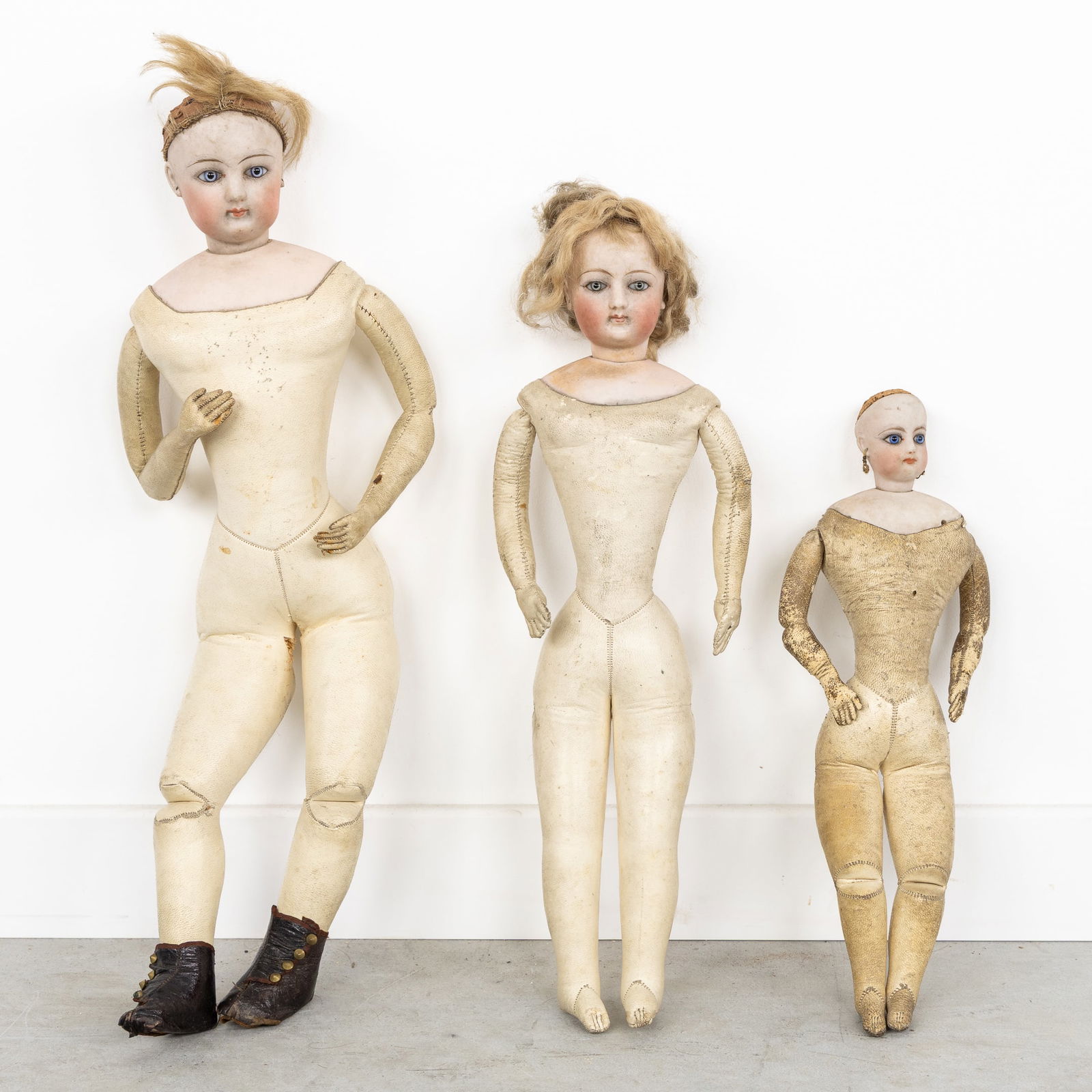 A Collection of Three Antique Dolls with Biscuit Porcelain Busts and Leather Bodies.: A Collection of Three Antique Dolls with Biscuit Porcelain Busts and Leather Bodies. Biscuit porcelain head and shoulders, glass eyes.Leather body and limbs.Probably Francois Gaultier, not signed.Fran