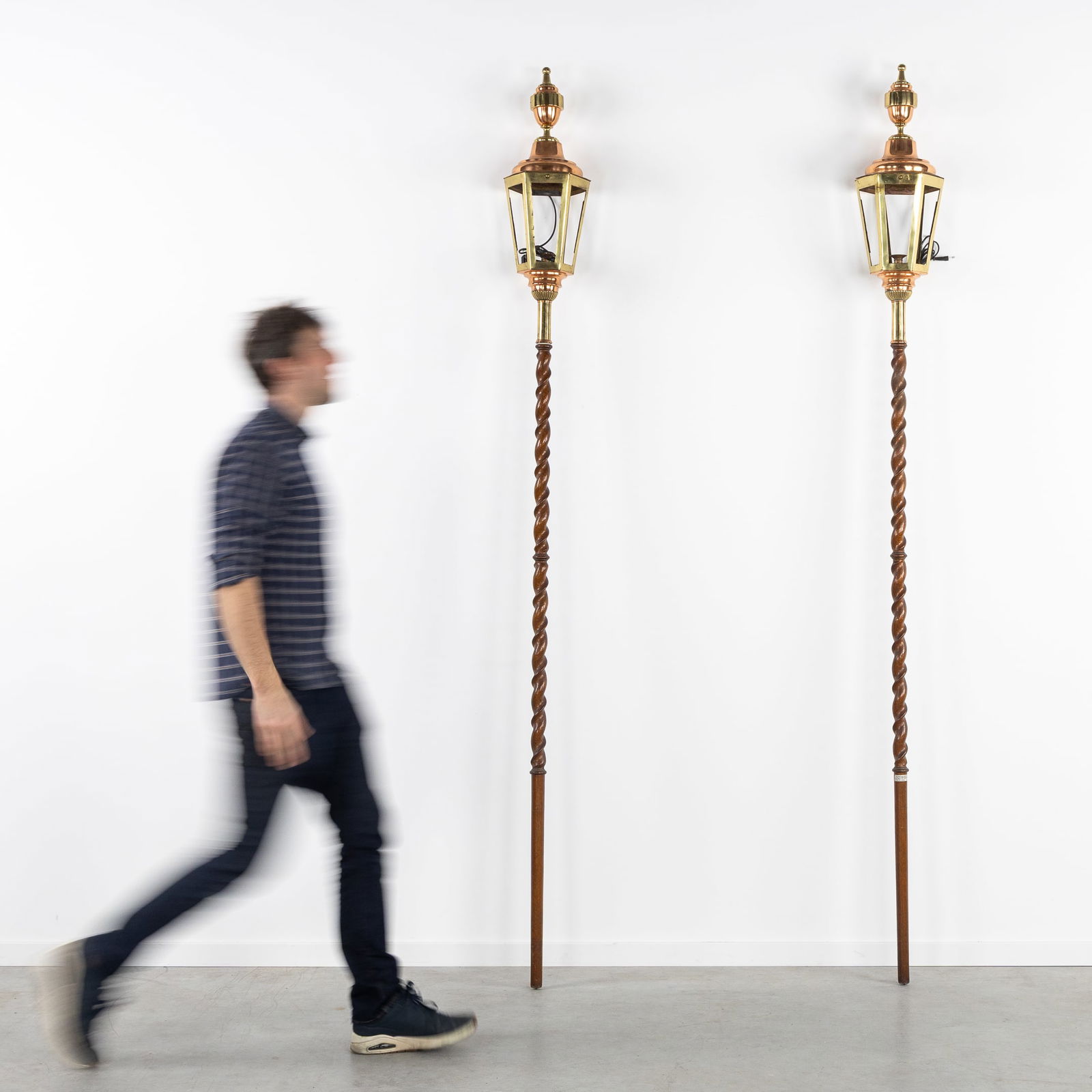 A Pair of Copper Lanterns, Mounted on Twisted Stands.: A Pair of Copper Lanterns, Mounted on Twisted Stands. Copper, brass, and wood.Electrified lanterns, mounted on twisted stands or poles. Lantern dimensions: H: 80 cm x W: 25 cm x D: 21 cmStand dimensio