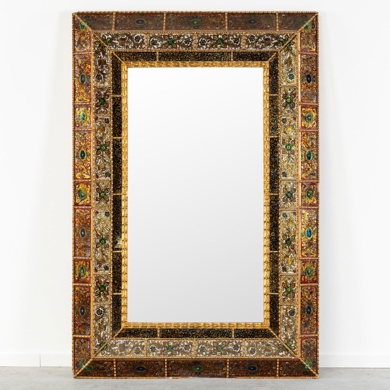 An Imposing Mirror with a Gilded Frame finished with Polychrome and Gilded Reverse Glass Paintings.