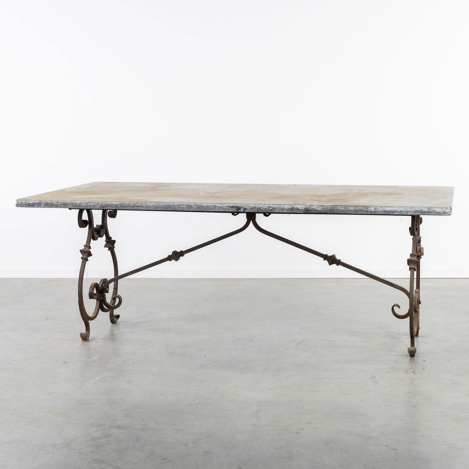 A Large Garden Table, Wrought Iron base and Bluestone tabletop.: A Large Garden Table, Wrought Iron base and Bluestone tabletop.