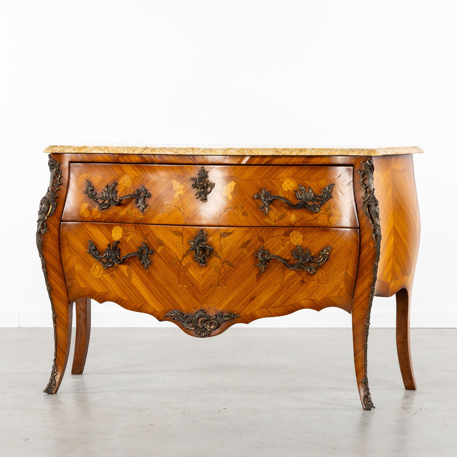 A Commode with a Marble Top, Louis XV style, Marquetry and Bronze Fittings, 20th C.: A Commode with a Marble Top, Louis XV style, Marquetry and Bronze Fittings, 20th century. Wood, bronze, and marble.Commode with two drawers, decorated with floral marquetry and parquetry.Finished