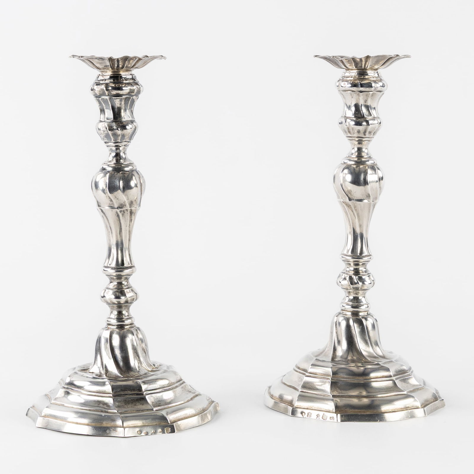Two 18th-century Silver Candlesticks, Louis XV period, Ath and Ghent, 1765 and 1771. Silver, 578g.: Two 18th-century Silver Candlesticks, Louis XV period, Ath and Ghent, 1765 and 1771. Silver. A pair of silver candlesticks, with bobeches.Louis XV period, Rococo. Silver hallmarks:City hallmarks for A