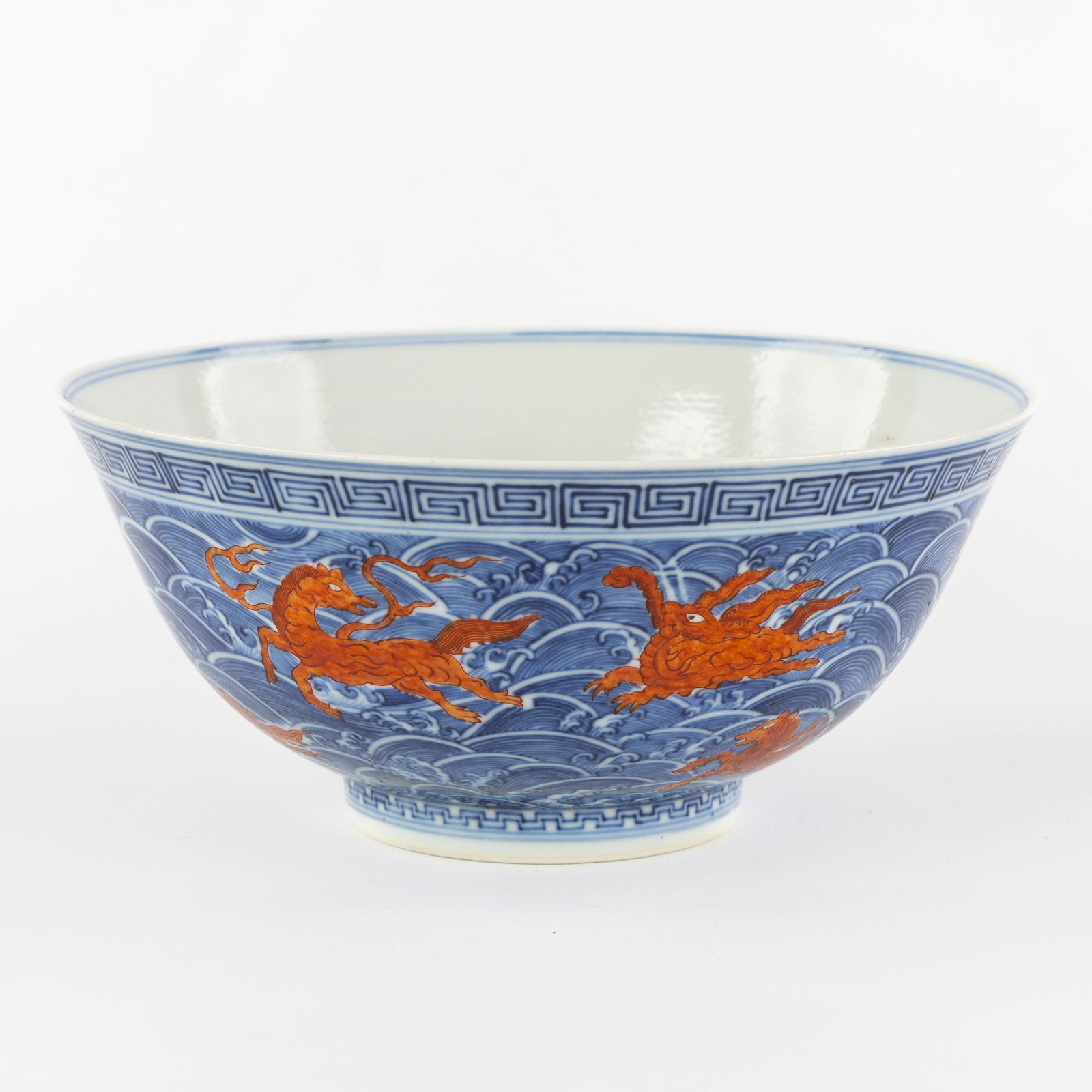 A Chinese blue-and-white bowl, decorated with iron-red 'sea creatures', Guangxu marked and period,: A Chinese blue-and-white bowl, decorated with iron-red 'sea creatures', Guangxu marked and period, 19th century. Chinese porcelain.A blue-white ground with a wave decoration and iron-red sea creatures