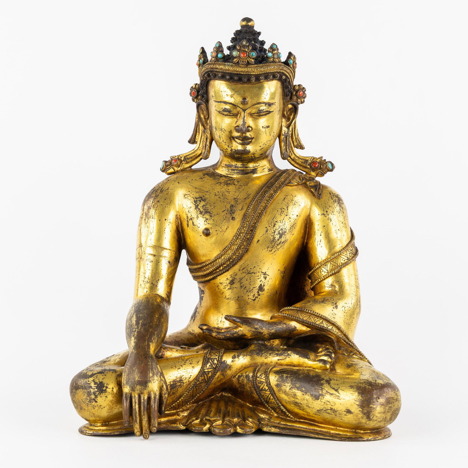 A Seated Akshobhya Buddha, gilded bronze, decorated with coral and turquoise cabochons, Ming: A Seated Akshobhya Buddha, gilded bronze, decorated with coral and turquoise cabochons, Ming Dynasty. Gilded bronze.Representation of the Akshobhya Buddha with a crown decorated with coral and turquoi