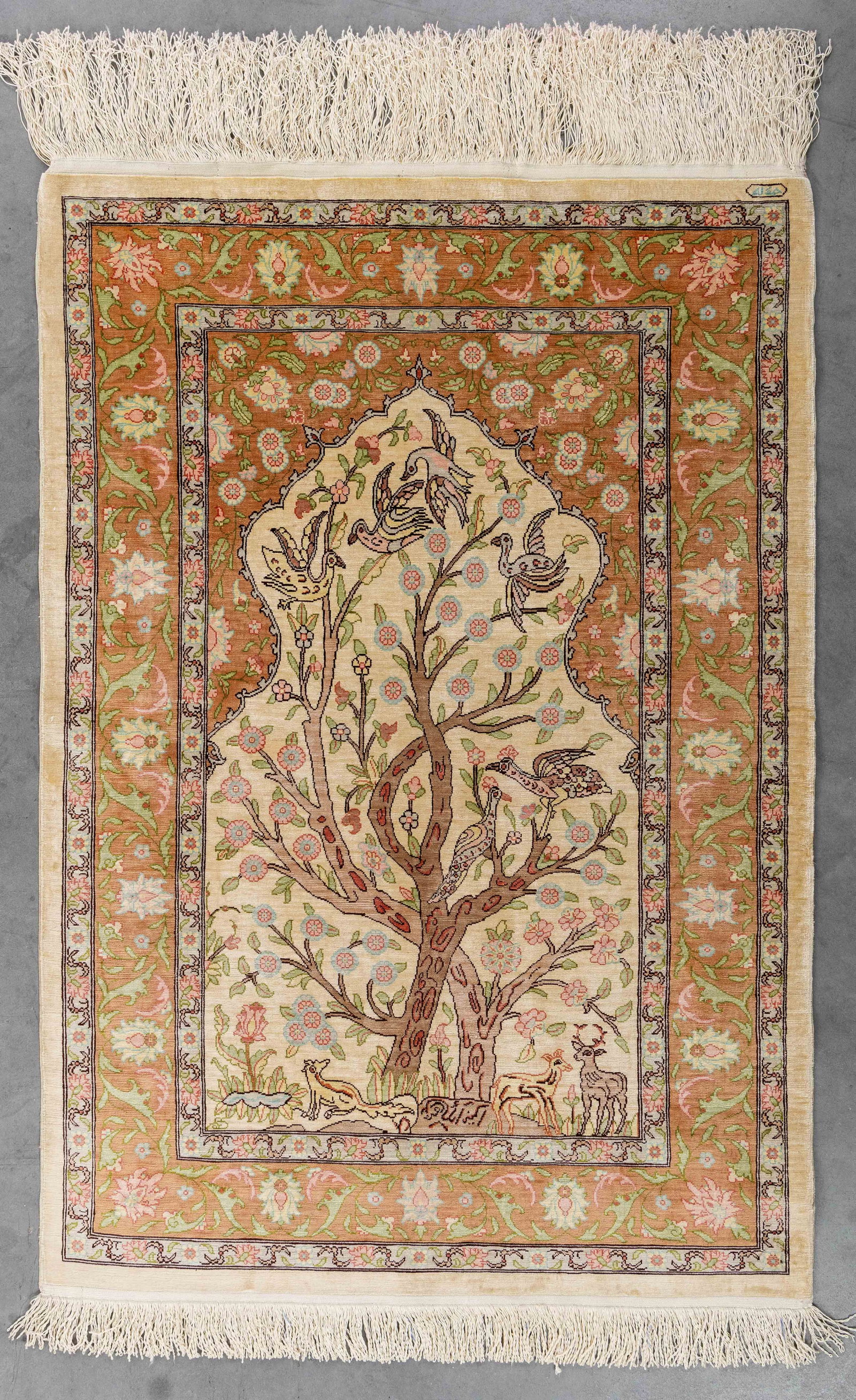 An Oriental hand-made carpet, silk, Hereke, Turkiye (101 x 69 cm).: An Oriental hand-made carpet, silk, Hereke, Turkiye (101 x 69 cm). With a Tree of Life decor.Signed. (69 x 101 x 0 cm)