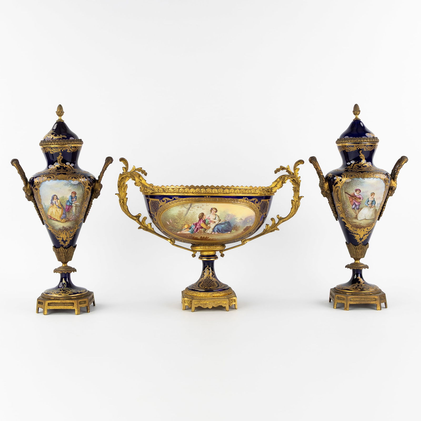 Sèvres, a pair of vases and a 'Milieu De Table', polychrome porcelain mounted with gilt bronze.: Sèvres, a pair of vases and a 'Milieu De Table', polychrome porcelain mounted with gilt bronze. Circa 1900. Pair