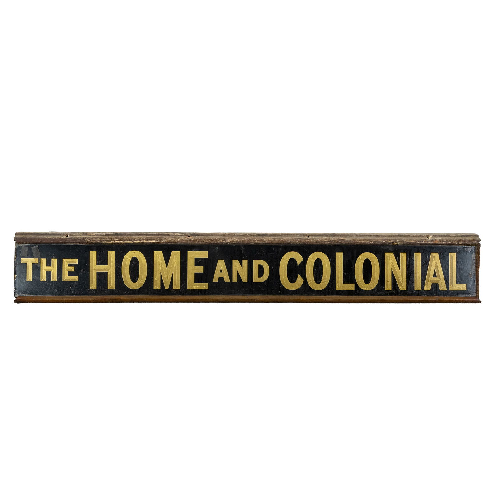 An Antique advertising sign, 'The Home and Colonial', glass and wood, England, circa 1920.: An Antique advertising sign, 'The Home and Colonial', glass and wood, England, circa 1920. Glass, wood, and copper. A glass panel, printed on reverse glass, mounted in a wooden frame. 'The Home and Co