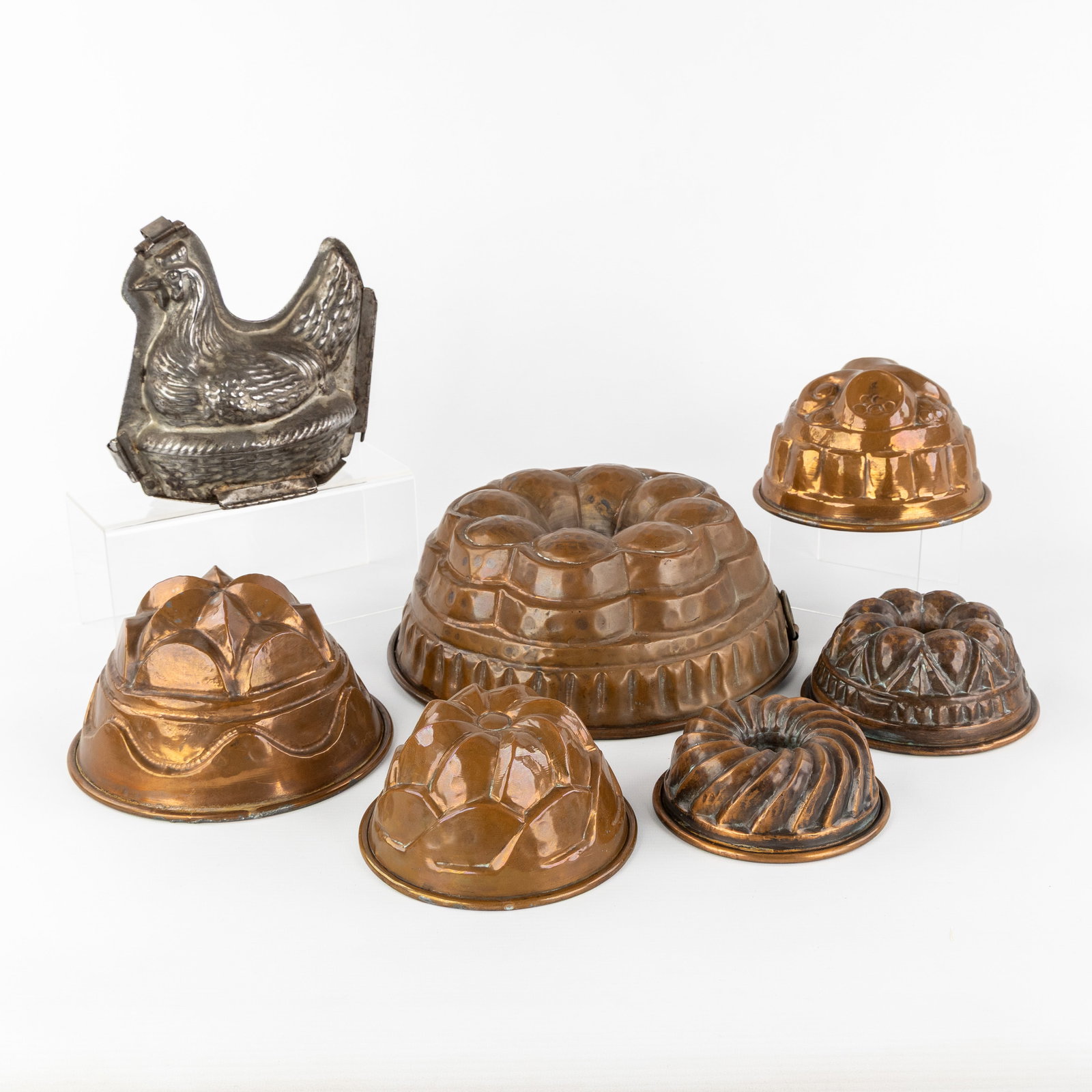 A Collection of 7 antique baking and chocolate molds, copper and metal, 19th/20th C.: A Collection of 7 antique baking and chocolate molds, copper and metal, 19th/20th century. Set of 6 Victorian baking or pudding molds, bundt molds, copper, 19th century.Smallest diameter: 12 cm / Larg