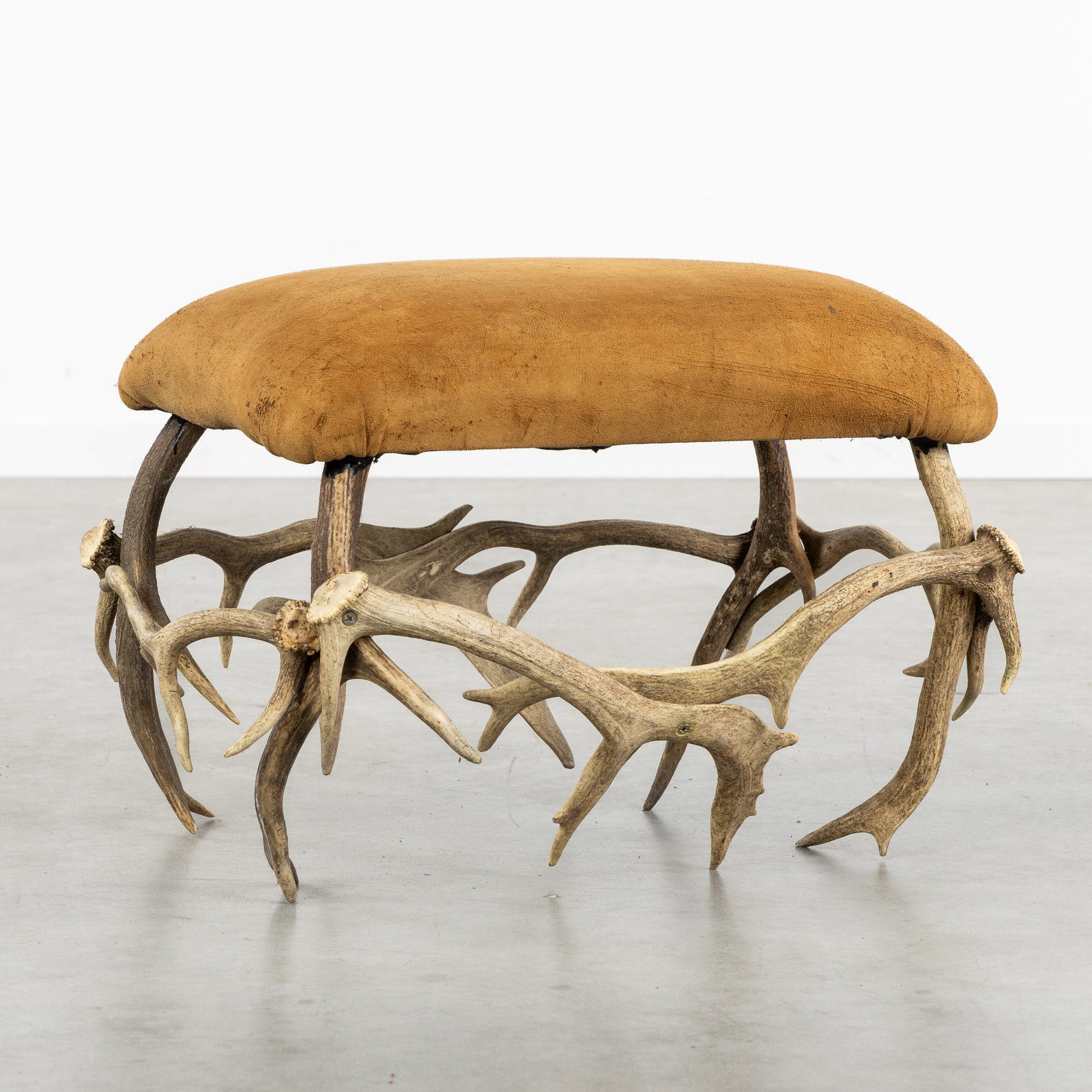 A Vintage Antler Footstool or Ottoman, Suede leather.: A Vintage Antler Footstool or Ottoman, Suede leather. Footstool with a base made of 8 antlers. Upholstered in suede leather. (70 x 45 x 50 cm)