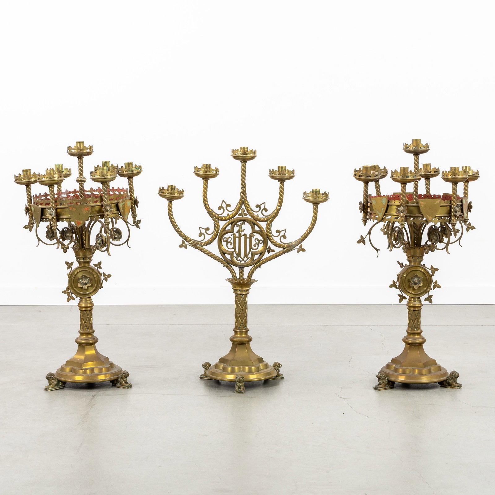 A three-piece set of church candlesticks, made of brass in Gothic Revival style. (1 of 7)