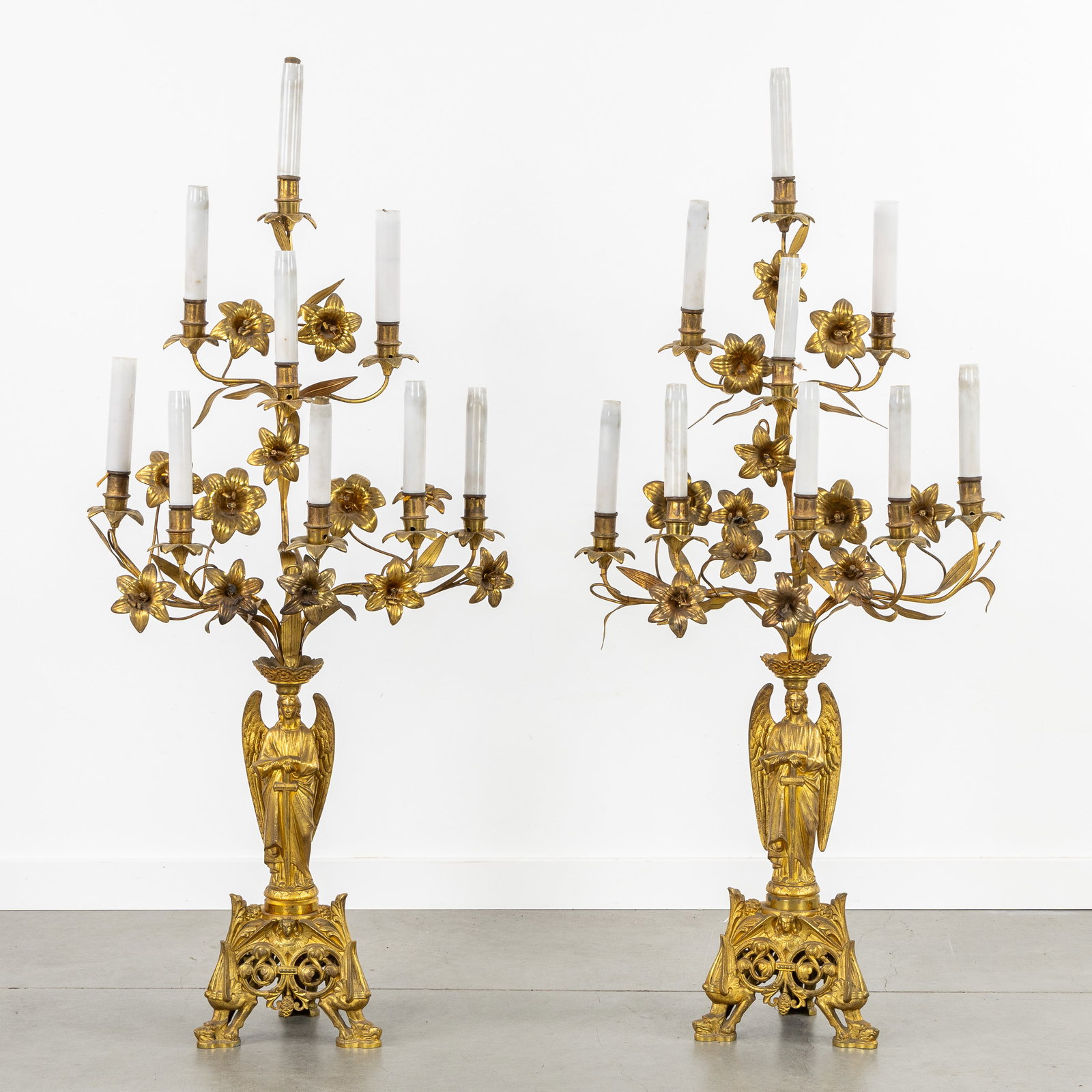 A Pair of large church or altar lamps with angels and lilies, gilded brass and bronze. Gothic: A Pair of large church or altar lamps with angels and lilies, gilded brass and bronze. Gothic Revival. Gilded brass and bronze.Church or altar lamps, with 9 electrified light points.Decorated with a