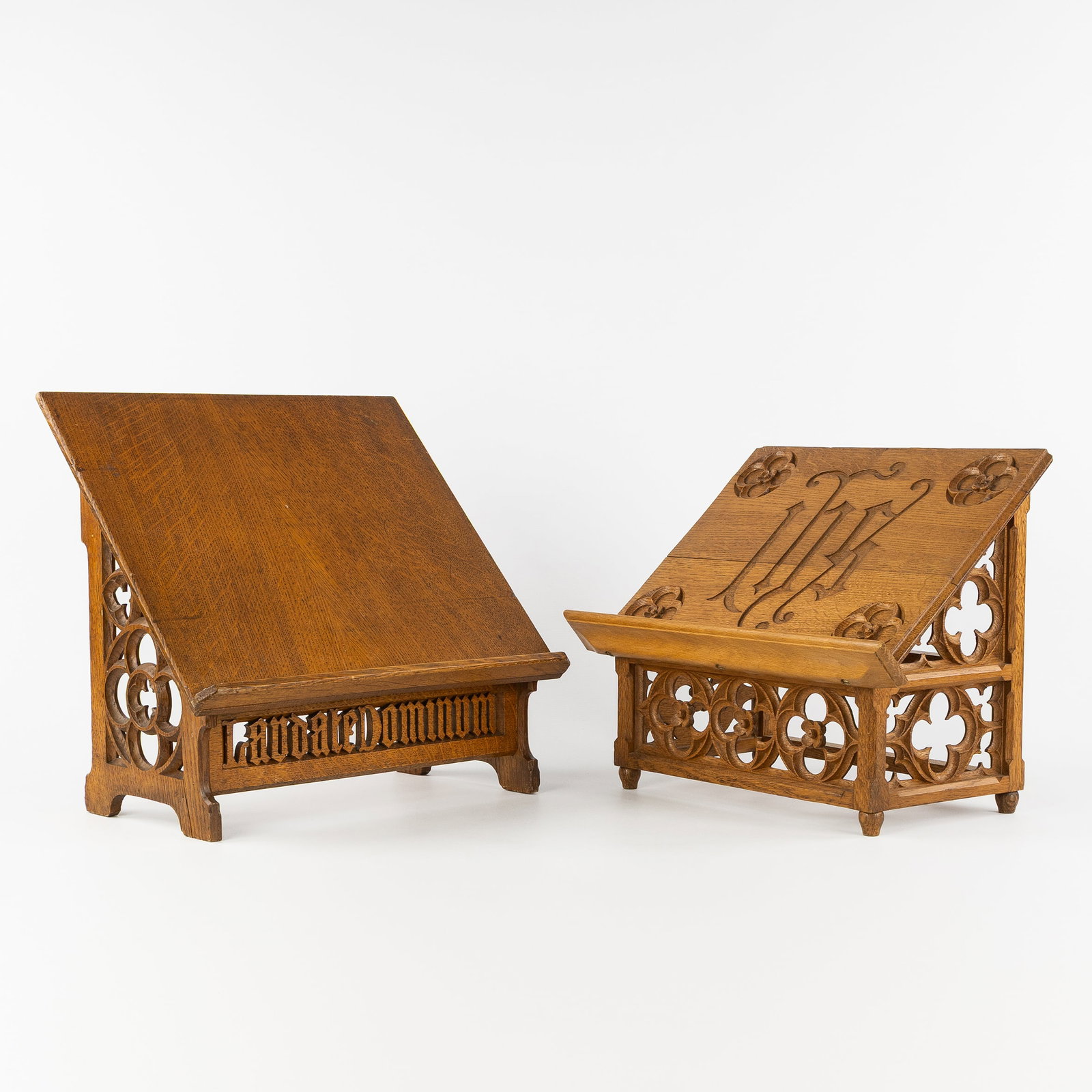 A pair of wood-sculptured lecterns, Gothic Revival.: A pair of wood-sculptured lecterns, Gothic Revival. Finished with an IHS monogram and Gothic tracery. Finished with an inscription 'Laudate Dominum' - 'Praise The Lord' 39 x 41,5 x 25 cm.&