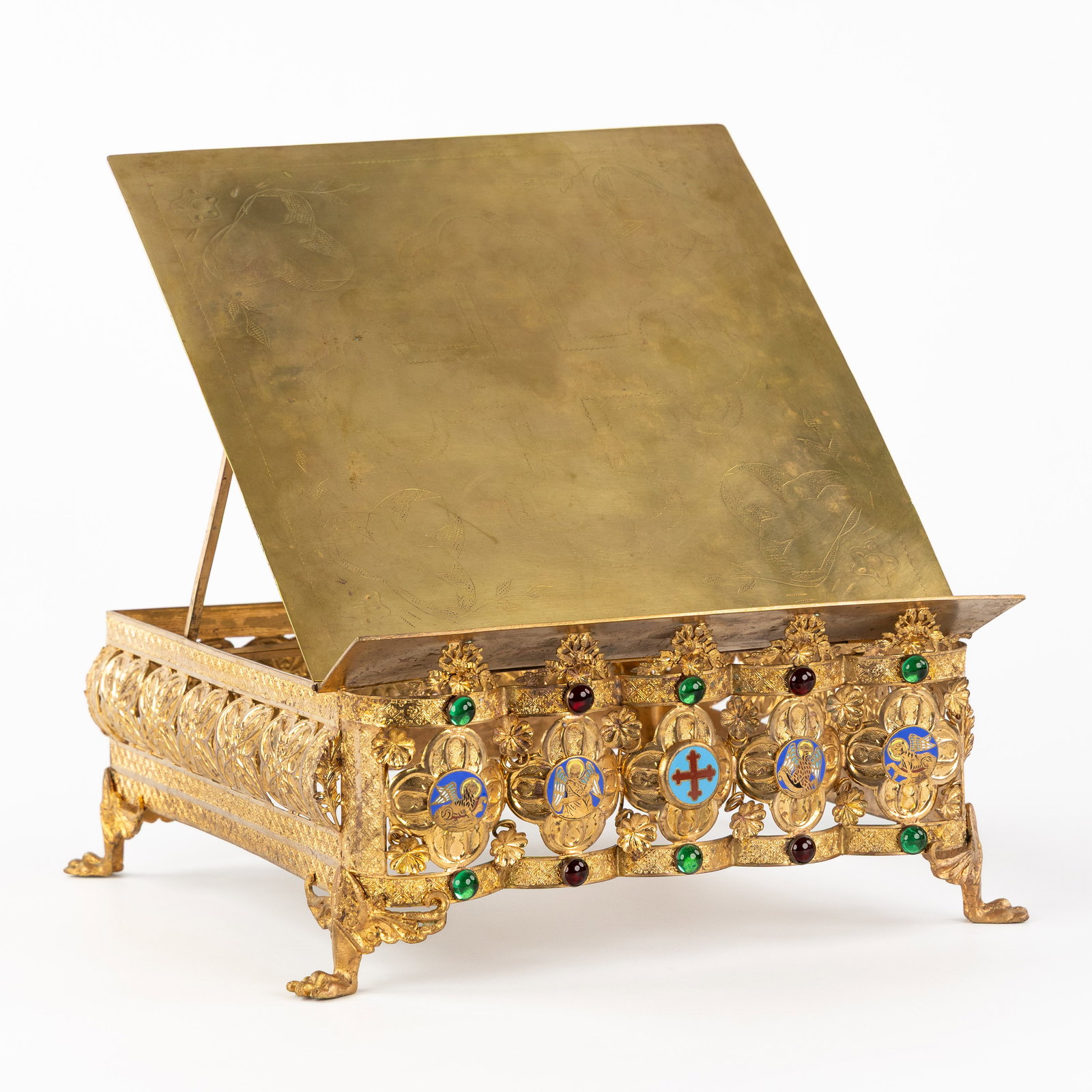 A lectern, made of gilded brass and finished with cabochons and enamel plaques depicting the Four: A lectern, made of gilded brass and finished with cabochons and enamel plaques depicting the Four Evangelists. Gothic Revival. Lectern made of gilded brass. The front is finished with cabochons a
