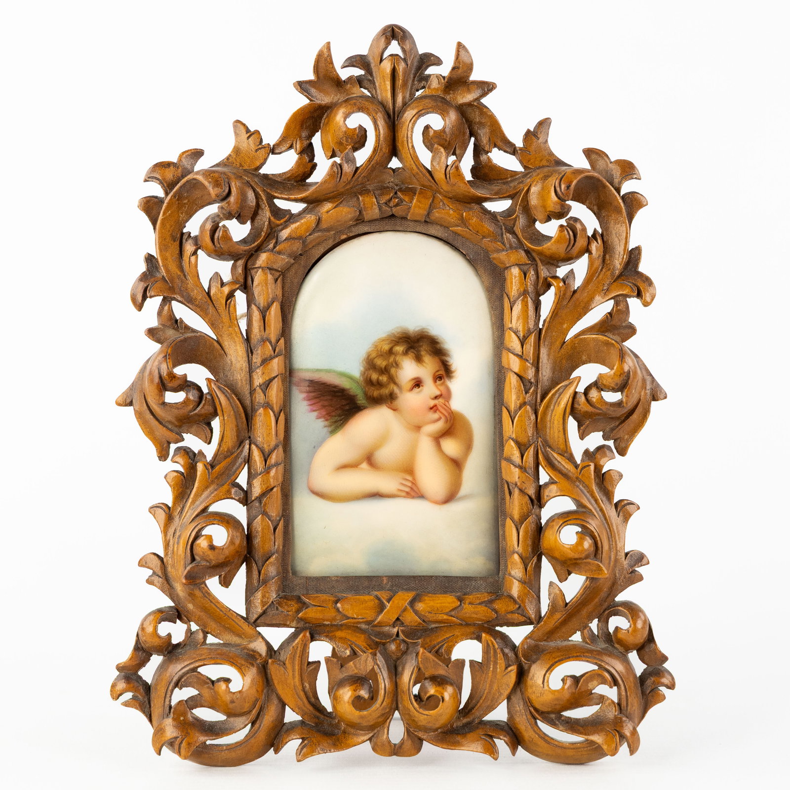 A Wood-sculptured frame with a porcelain plaque of a Sistine Chapel cherub. (1 of 3)