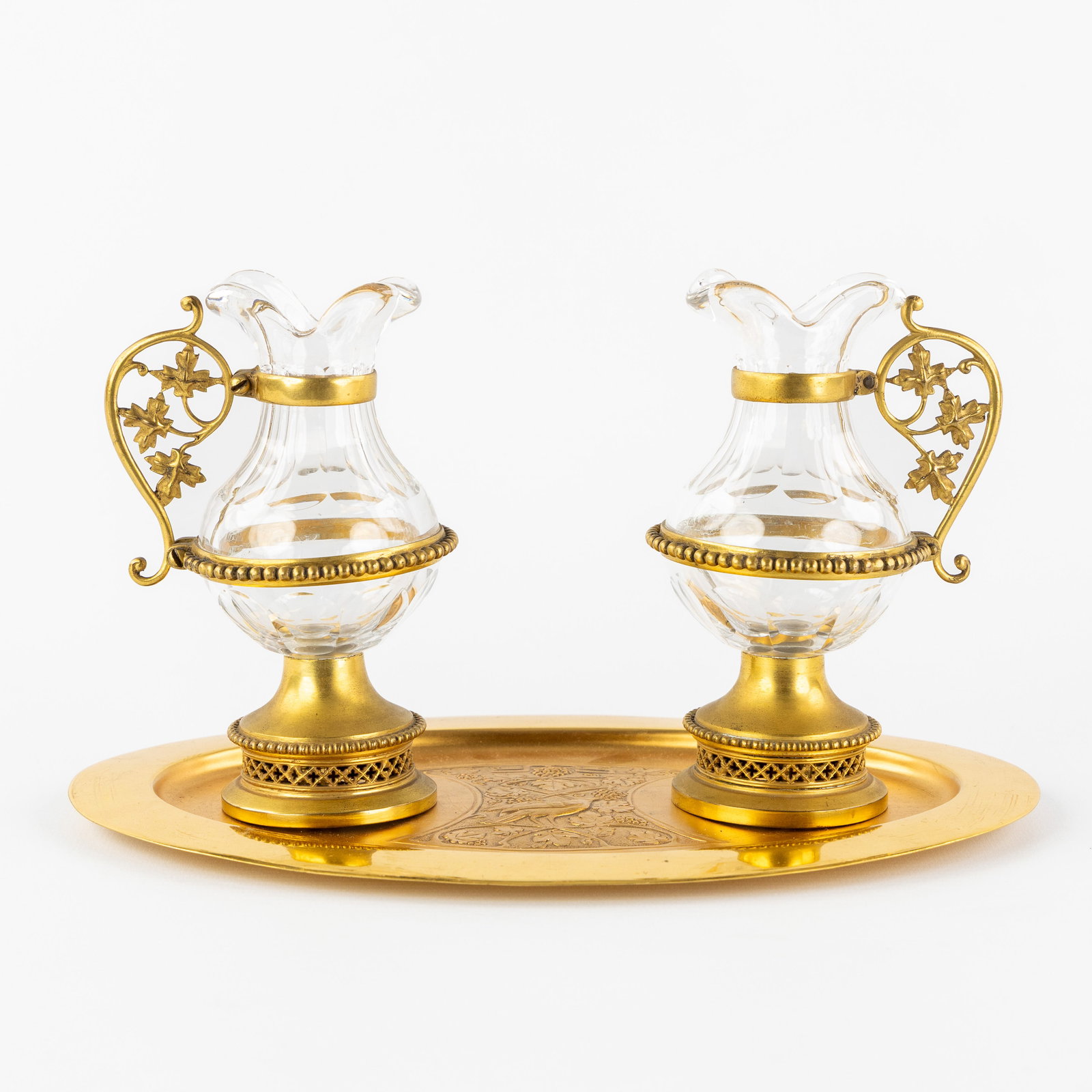 A Pair of wine and water altar cruets, Gothic Revival, gilded brass and cut crystal.: A Pair of wine and water altar cruets, Gothic Revival, gilded brass and cut crystal. Altar cruets or ampoules, decorated with grape vines, pearl mouldings, and openwork moulding with Gothic tracery. M