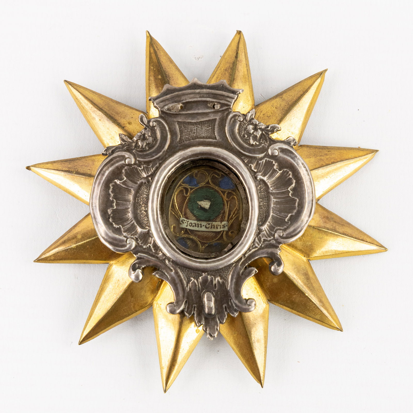 A sealed theca containing a relic of Saint John Chrysostom, set in a brass osculatorium. 18th and (1 of 2)