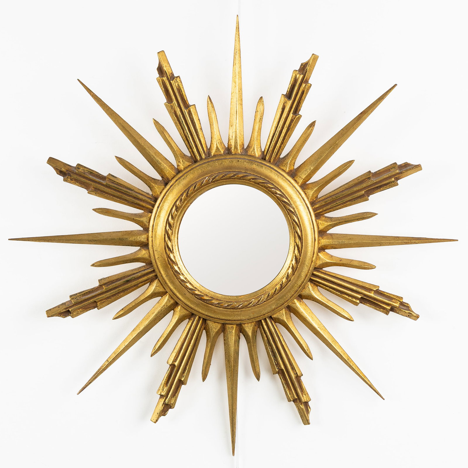 A Mid-Century Sunburst mirror, gilded and wood-sculptured, Convex Glass. Circa 1970.: A Mid-Century Sunburst mirror, gilded and wood-sculptured, Convex Glass. Circa 1970. Convex glass.Gilded wood.Circa 1970. Dimensions: (W:66 cm) The absence of a condition report does not imply a perfe