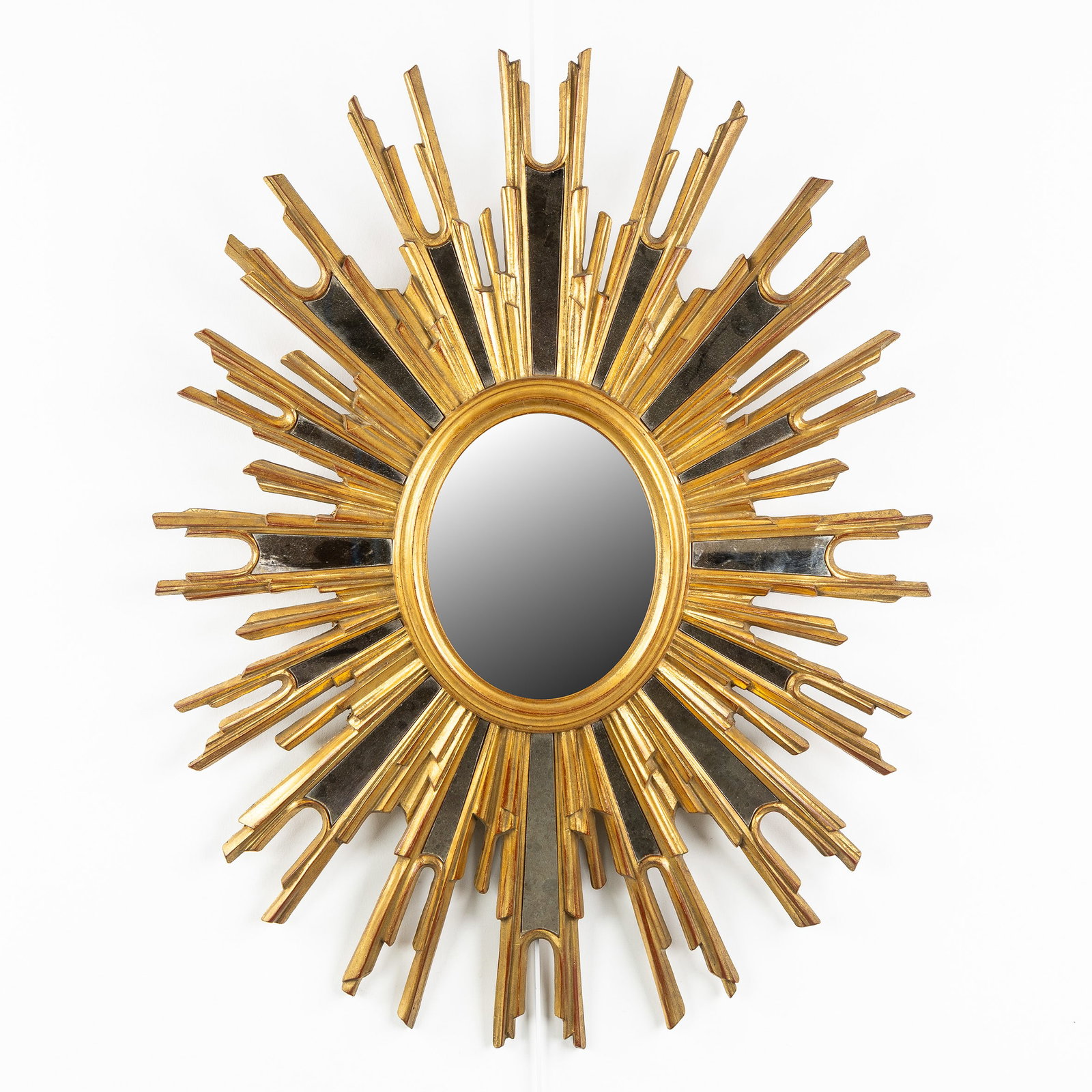 Deknudt, a Large Oval Mid-Century Sunburst mirror, gilded, convex glass. Circa 1970.: Deknudt, a Large Oval Mid-Century Sunburst mirror, gilded, convex glass. Circa 1970. Convex glass.Gilded resin.Labeled for Deknudt.Circa 1970. Dimensions: (W:87 x H:67 cm) The absence of a condition r