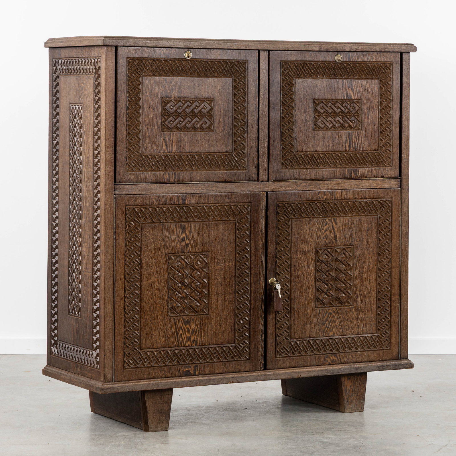 A Vintage bar cabinet, Colonial-style with fine sculptured framework, circa 1960.: A Vintage bar cabinet, Colonial-style with fine sculptured framework, circa 1960. Sculptured wood, probably Wenge.Bar cabinet with two drop-down doors and a two-door cabinet.Circa 1960. Dimensions: (W