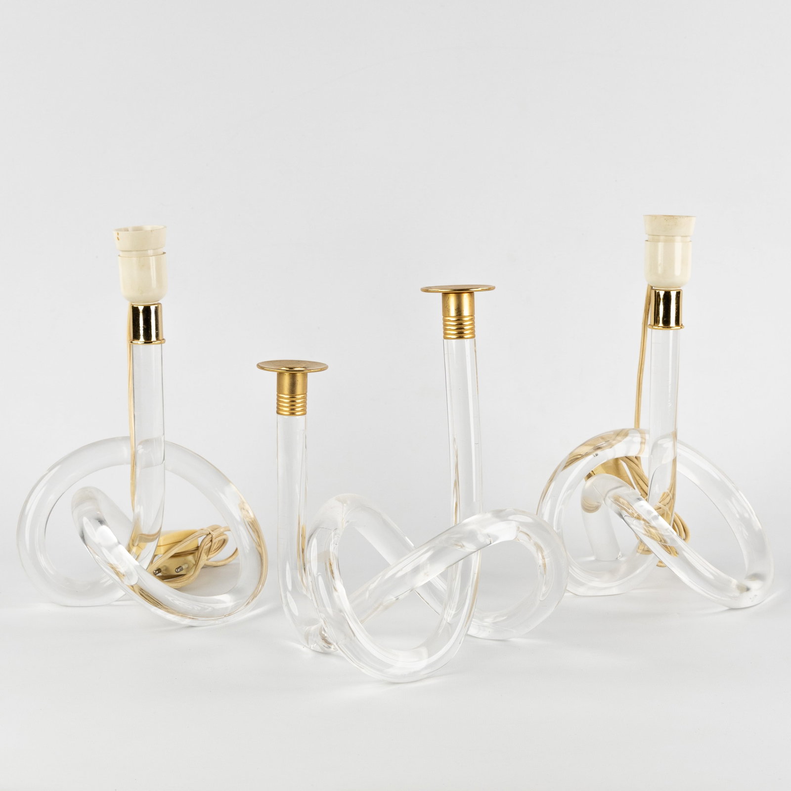Dorothy Thorpe Inc., 'Pretzel', a pair of table lamps and a candelabra, lucite and gilded metal, (1 of 7)