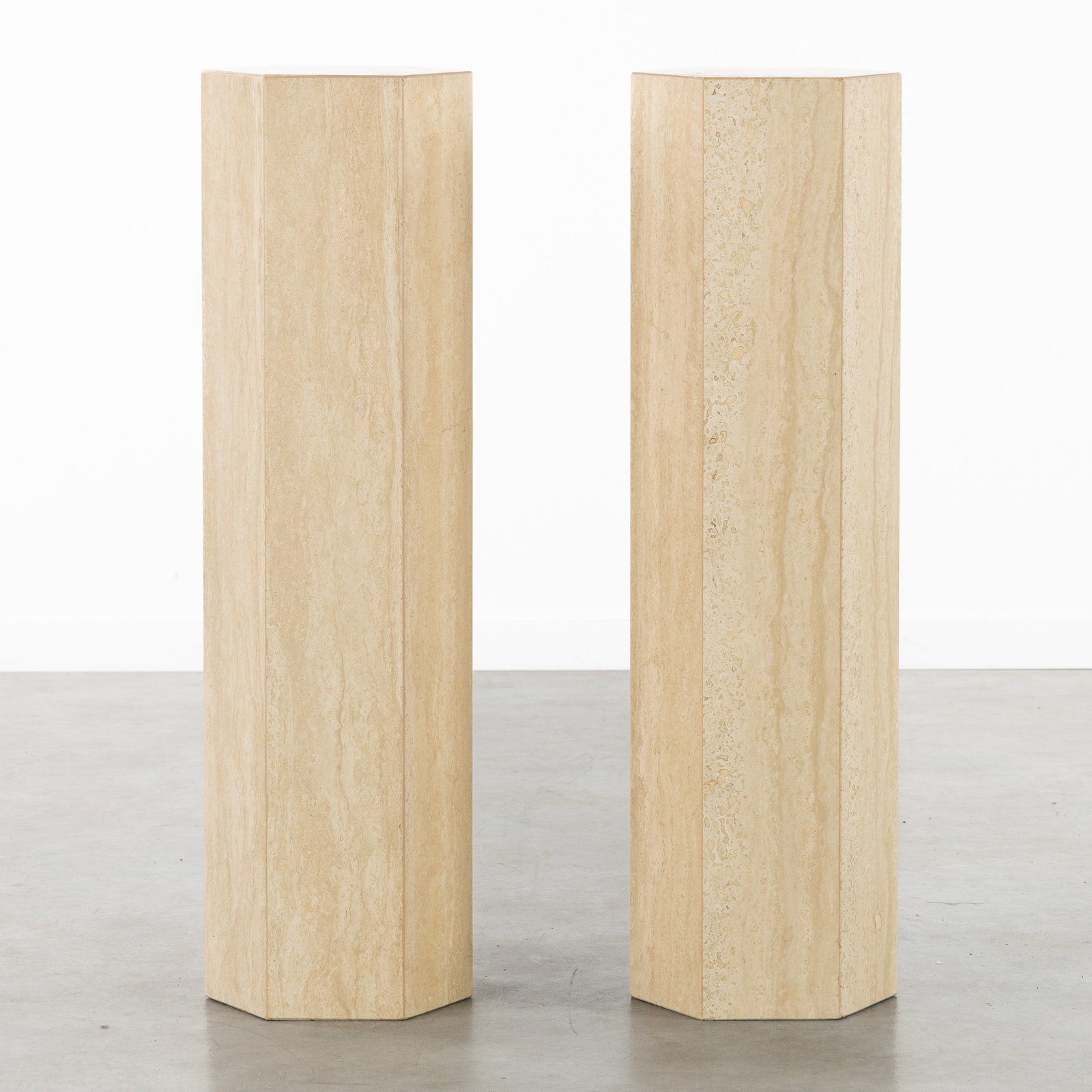 A Pair of decorative hexagonal Consoles or Pedestals, travertine.: A Pair of decorative hexagonal Consoles or Pedestals, travertine. Dimensions: (W:26 x H:90 x L:23 cm) The absence of a condition report does not imply a perfect item. Please send us an e-mail to reque