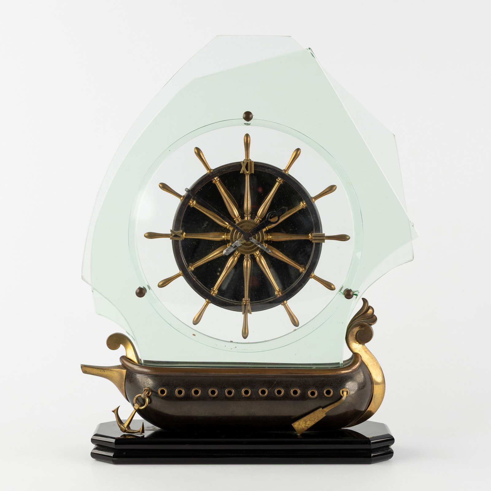 A 'Sailing Ship' mantel clock with rudder-shaped dial, patinated bronze, brass, and glass. Circa (1 of 7)