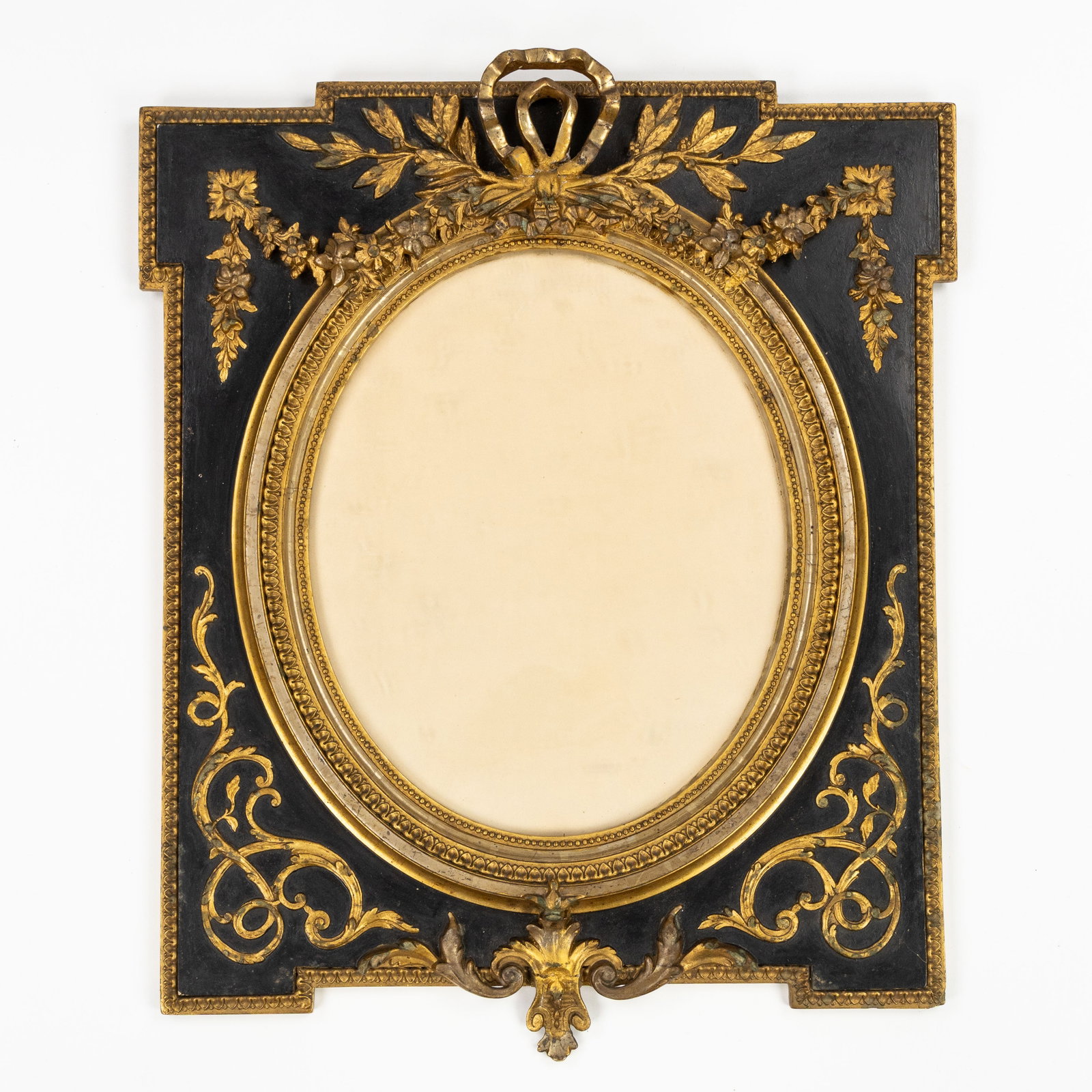 A Decorative frame, Louis XVI style, patinated and gilded wood.: A Decorative frame, Louis XVI style, patinated and gilded wood. Sculptured, patinated and gilded wood, and glass.Louis XVI style, decorated with a bow and garlands. Dimensions: (W:48 x H:58 cm) The ab
