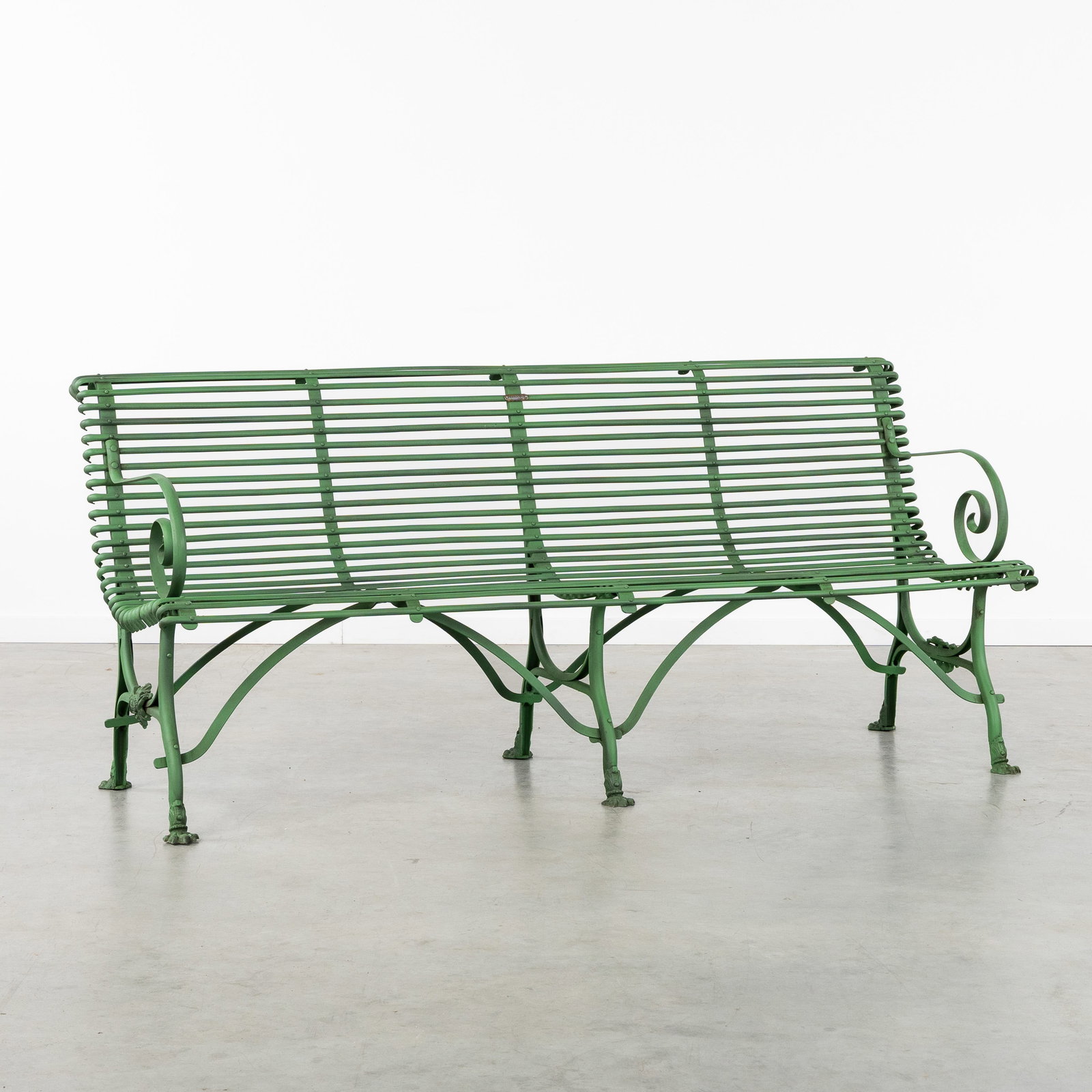 A green patinated metal garden bench with armrests.: A green patinated metal garden bench with armrests. With an inscription referring to S. Sauver, Arras. Dimensions: (W:184 x H:81 x L:73 cm) The absence of a condition report does not imply a perfect i