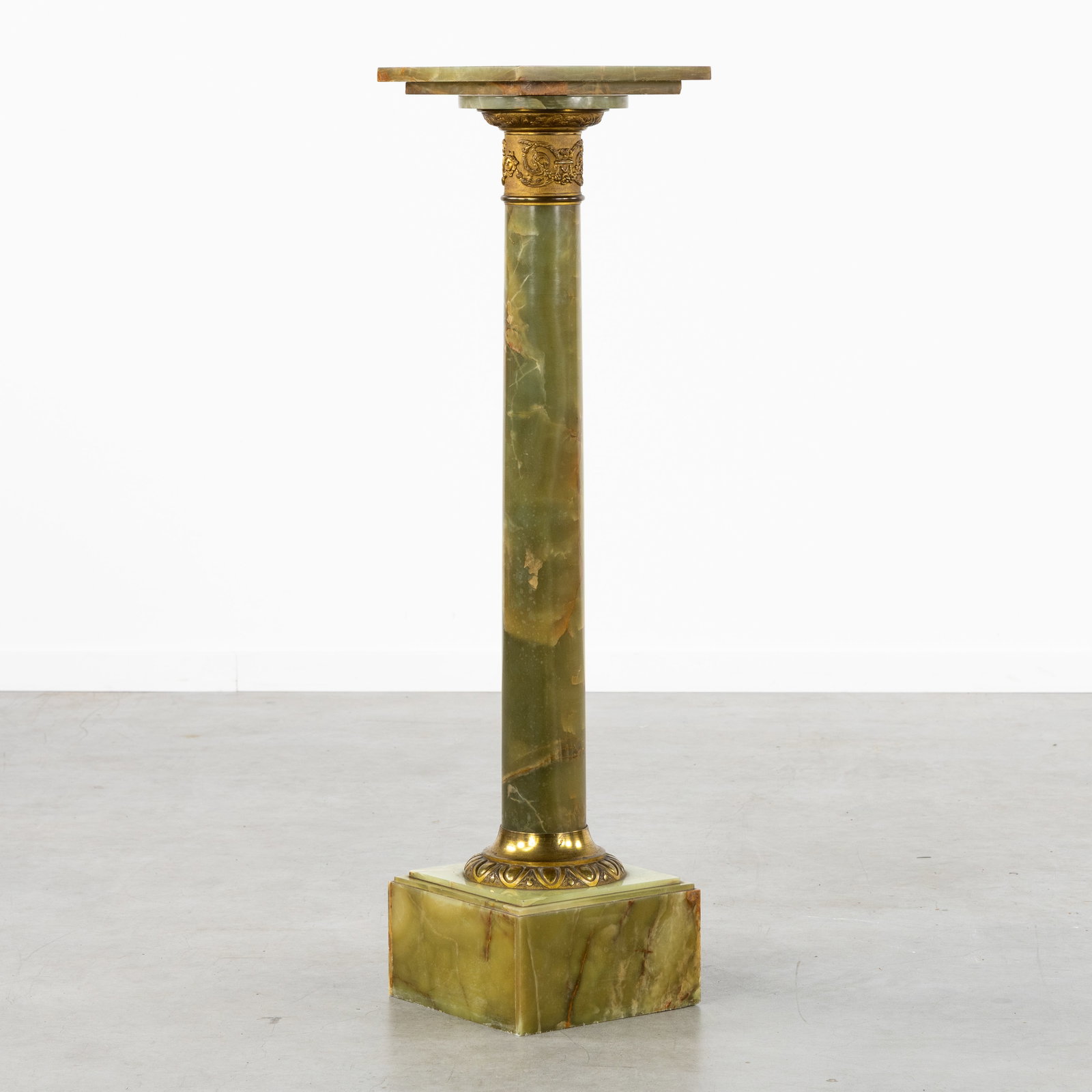 An Onyx console or pedestal with a rotating platform and bronze fittings, 19th/20th C.: An Onyx console or pedestal with a rotating platform and bronze fittings, 19th/20th century. Green onyx, finished with bronze fittings.Platform dimensions: 27.5 x 27.5 cm. Dimensions: (W:26 x H:108 x 