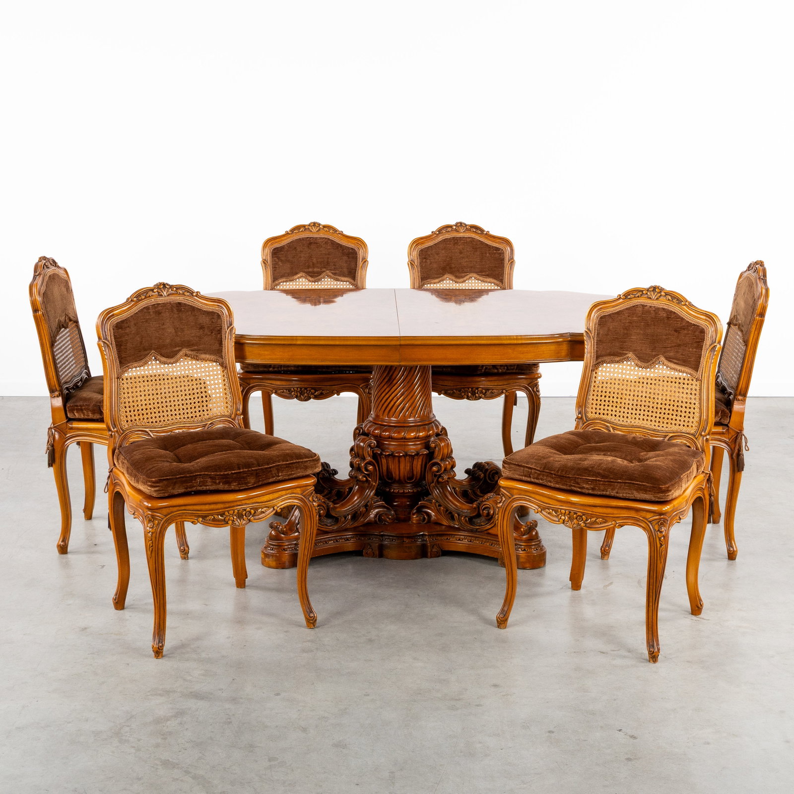 An impressive table with marquetry and a richly sculptured base, and six caned chairs, Louis XV (1 of 10)