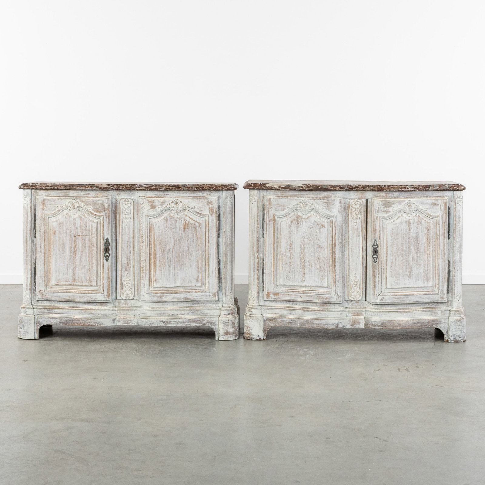 A Pair of decorative white patinated sideboards with Rouge Royal marble tops, Baroque style.: A Pair of decorative white patinated sideboards with Rouge Royal marble tops, Baroque style. Sculptured and patinated wood.Marble top, Rouge Royal or Rouge Belge.Sideboards, buffets, or two-door cabin