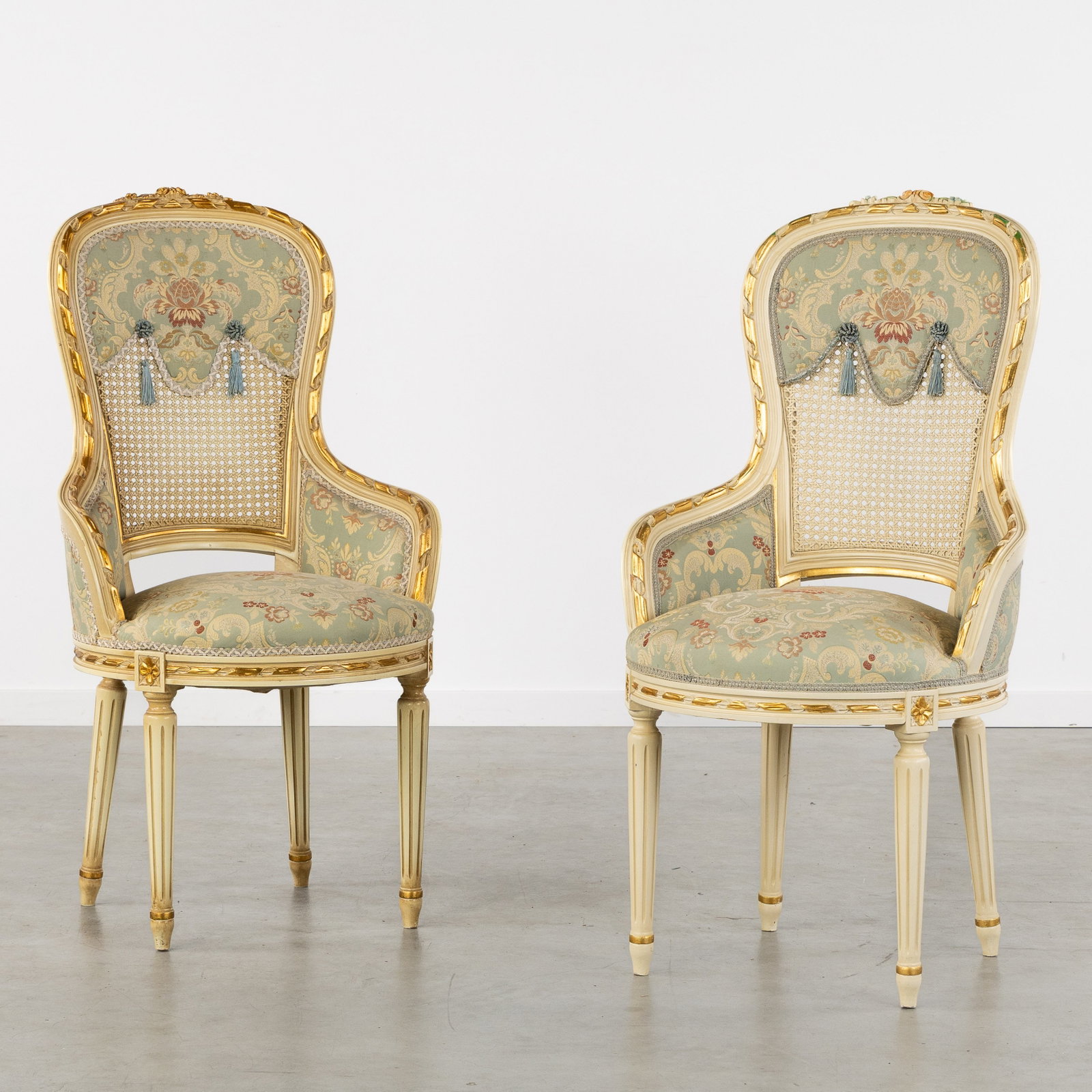 A Pair of decorative Armchairs with Embroidery and Cane, sculptured and patinated wood, Louis XVI: A Pair of decorative Armchairs with Embroidery and Cane, sculptured and patinated wood, Louis XVI style, 20th century. Sculptured, patinated, and gilded wood. Decorated with sculptured moldings, flowe
