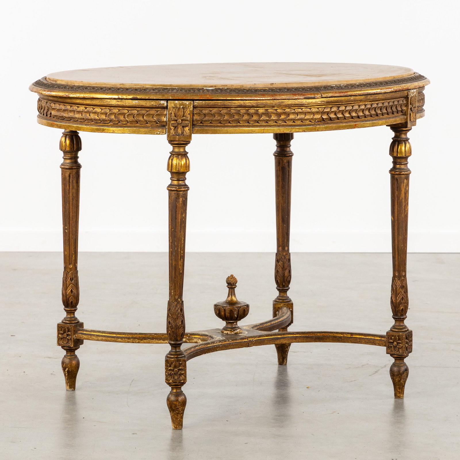 A Wood-sculptured and gilded side table with a Marble top. Louis XVI style.: A Wood-sculptured and gilded side table with a Marble top. Louis XVI style. Sculptured and gilded wood.Decorated with moldings, acanthus leaves, and rosettes.X-shaped connection between the legs finis