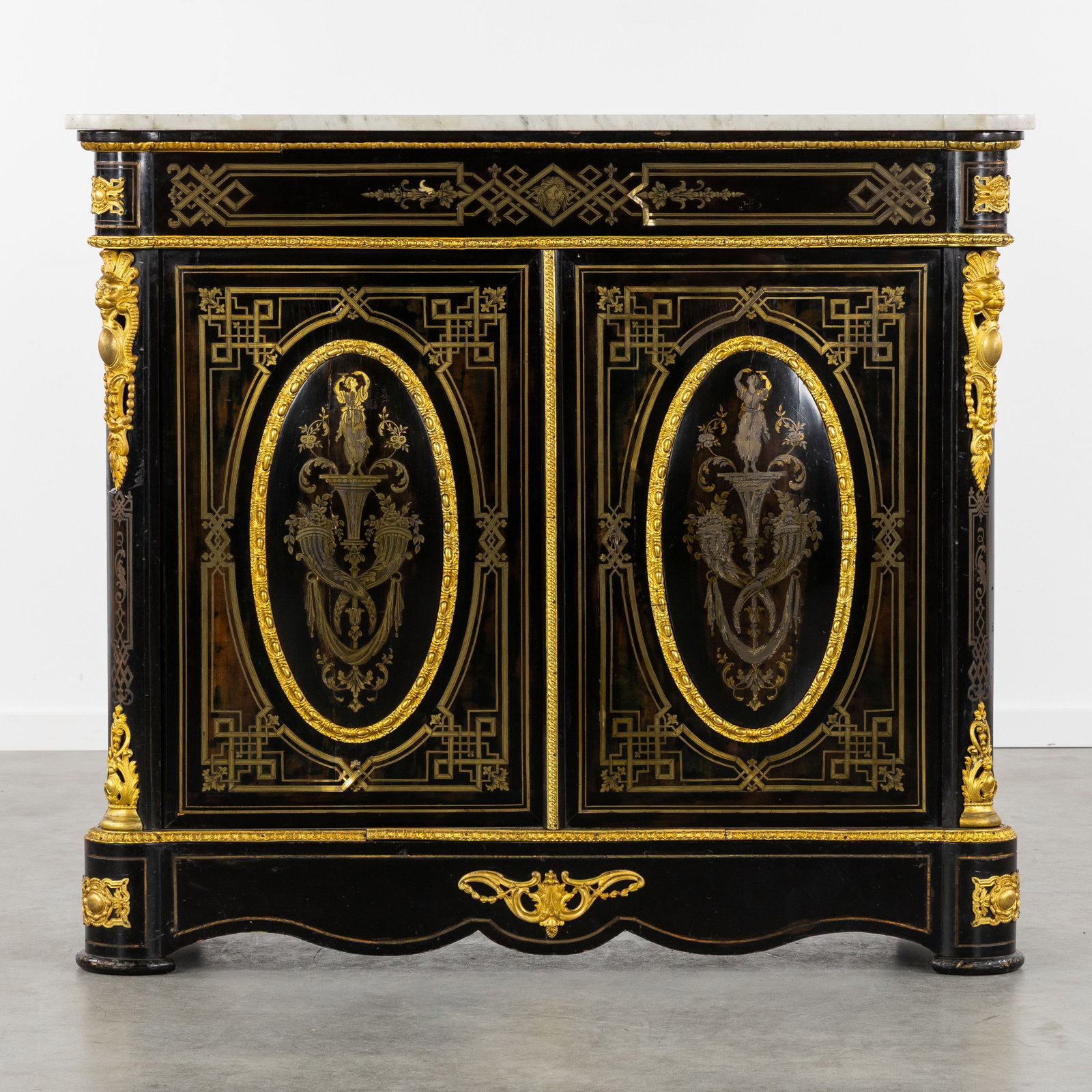 A Sideboard or Buffet cabinet with a marble top, Napoleon III, brass inlay, and mounted with gilded: A Sideboard or Buffet cabinet with a marble top, Napoleon III, brass inlay, and mounted with gilded bronze. Two-door cabinet with a white marble top. Ebonized wood with brass inlay, figurative decorat