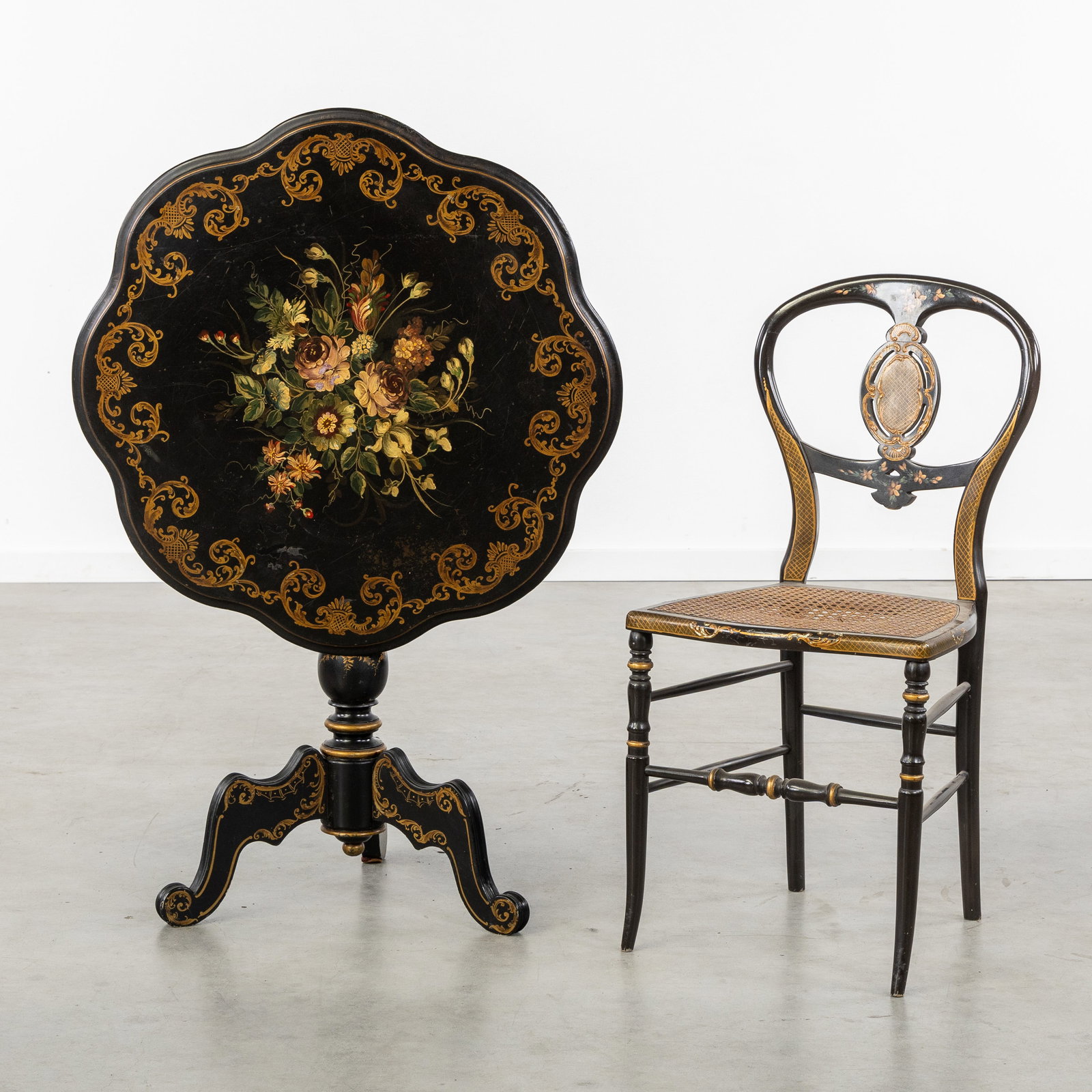 A Black lacquered Napoleon III tilt top table with hand-painted floral decoration and accompanying (1 of 6)