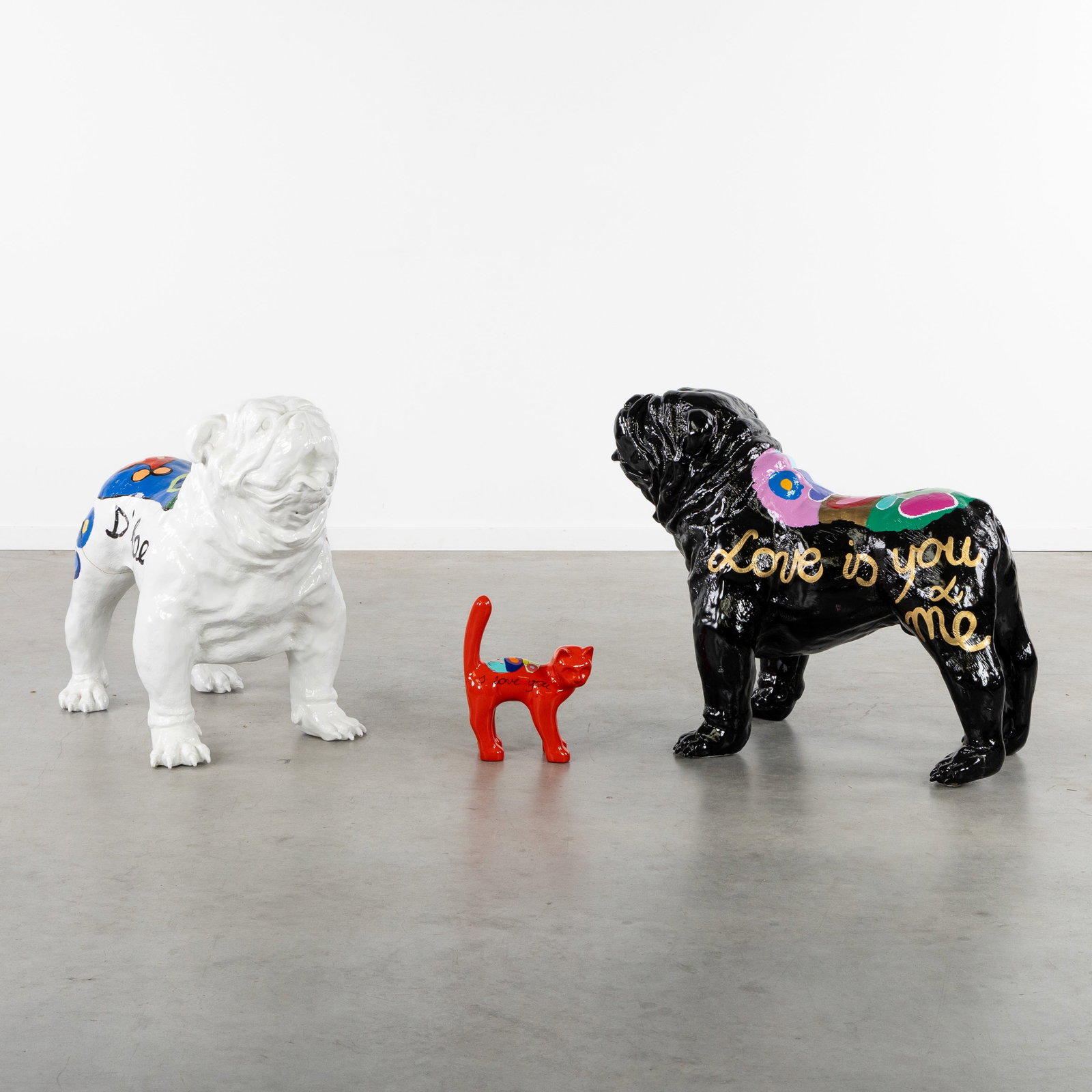 Hannes D'Haese (1965) Two Bulldogs and Cat, patinated polyester.: Hannes D'Haese (1965) Two Bulldogs and Cat, patinated polyester. 'Love is You and Me', 'I Love You'.Signed D'Haese. Bulldog: H: 71 cm x W: 50 cm x D: 90 cm.Cat: H: 33 cm x W: 26 cm x D: 13 cm. Dimensi