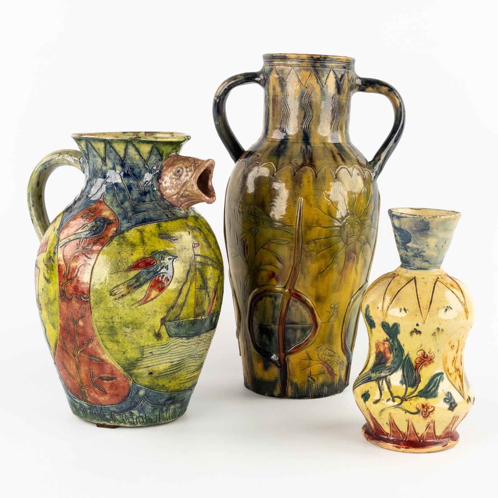Bredene Pottery, a pitcher and two vases.: Bredene Pottery, a pitcher and two vases. Finished with oxblood glaze and the typical colors for Bredene.Large vase with decoration of an elephant, sun, and bird.39 x 22 x 17 cm. Pitcher with decorati