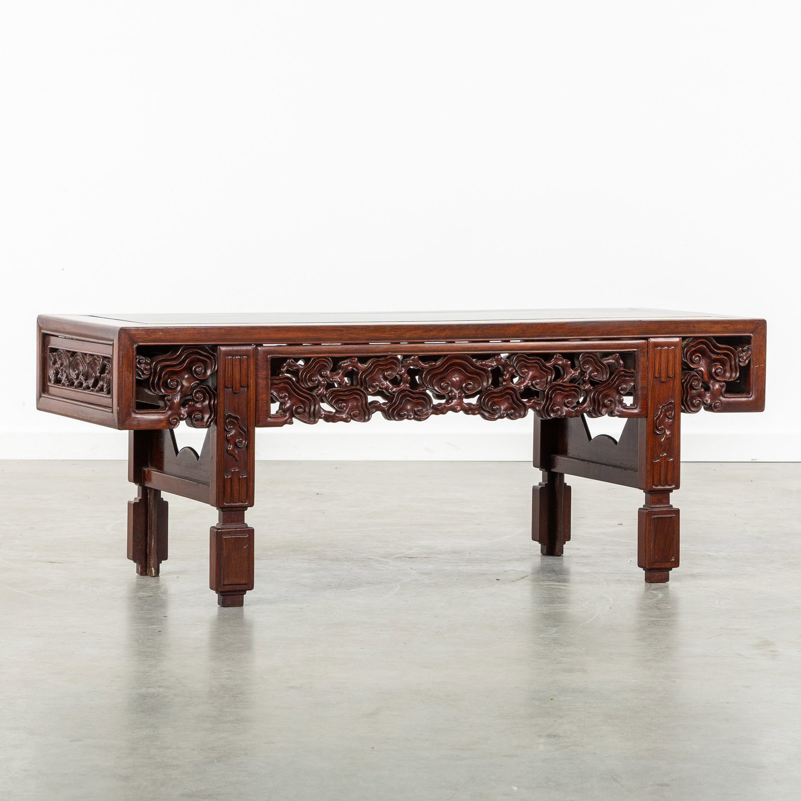 A Chinese low table or altar table, hardwood with openwork sculptured Lingzhi decor, 19th/20th C.: A Chinese low table or altar table, hardwood with openwork sculptured Lingzhi decor, 19th/20th century. Hardwood, possibly Zitan or Huanghuali. Dimensions: (W:114 x H:44 x L:43 cm) The absence of a co