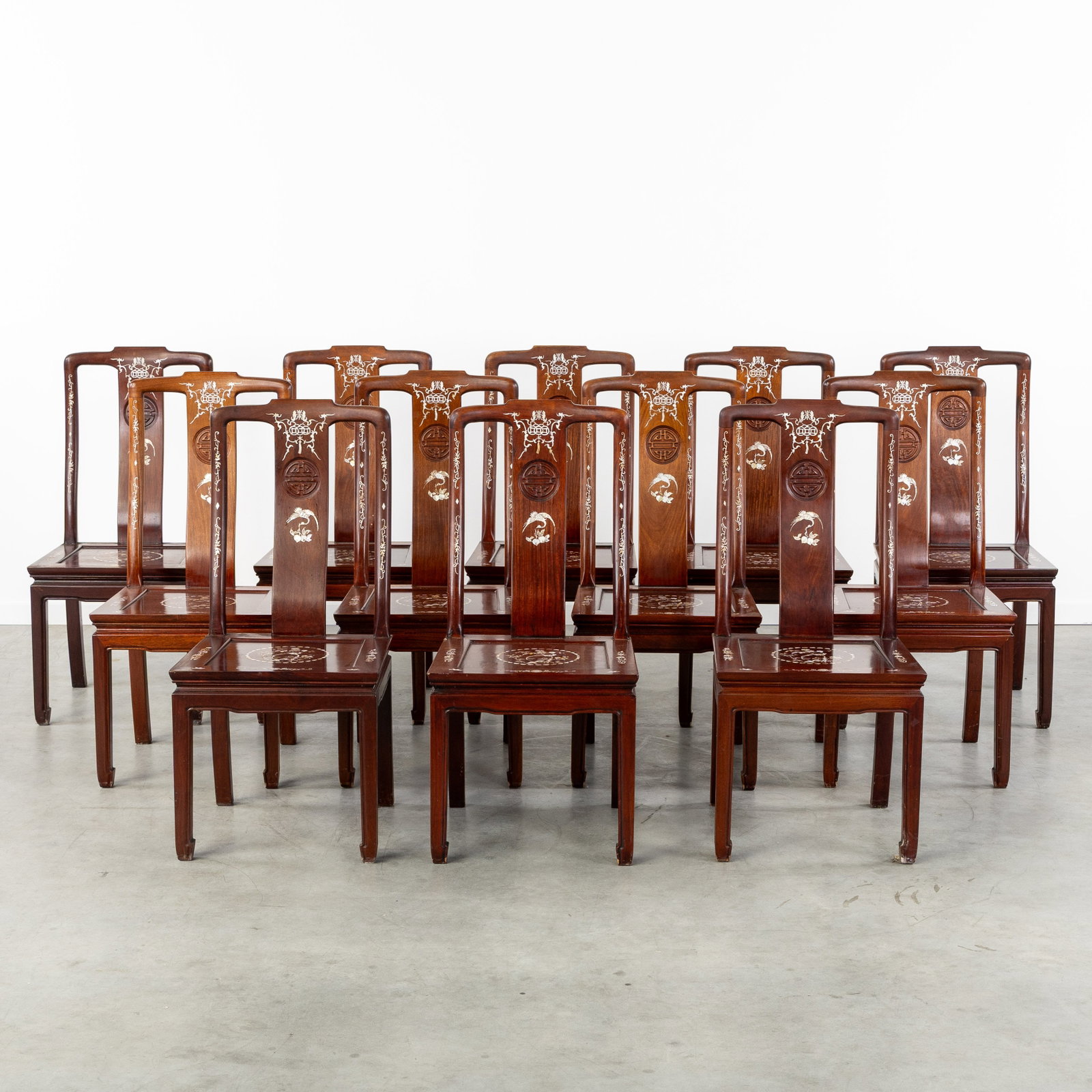 A Set of 12 Chinese chairs, Sculptured hardwood with mother-of-pearl inlay. 20th C.: A Set of 12 Chinese chairs, Sculptured hardwood with mother-of-pearl inlay. 20th century. Sculptured hardwood.Finely decorated with mother-of-pearl inlay with floral motifs and birds.China, 20th centu